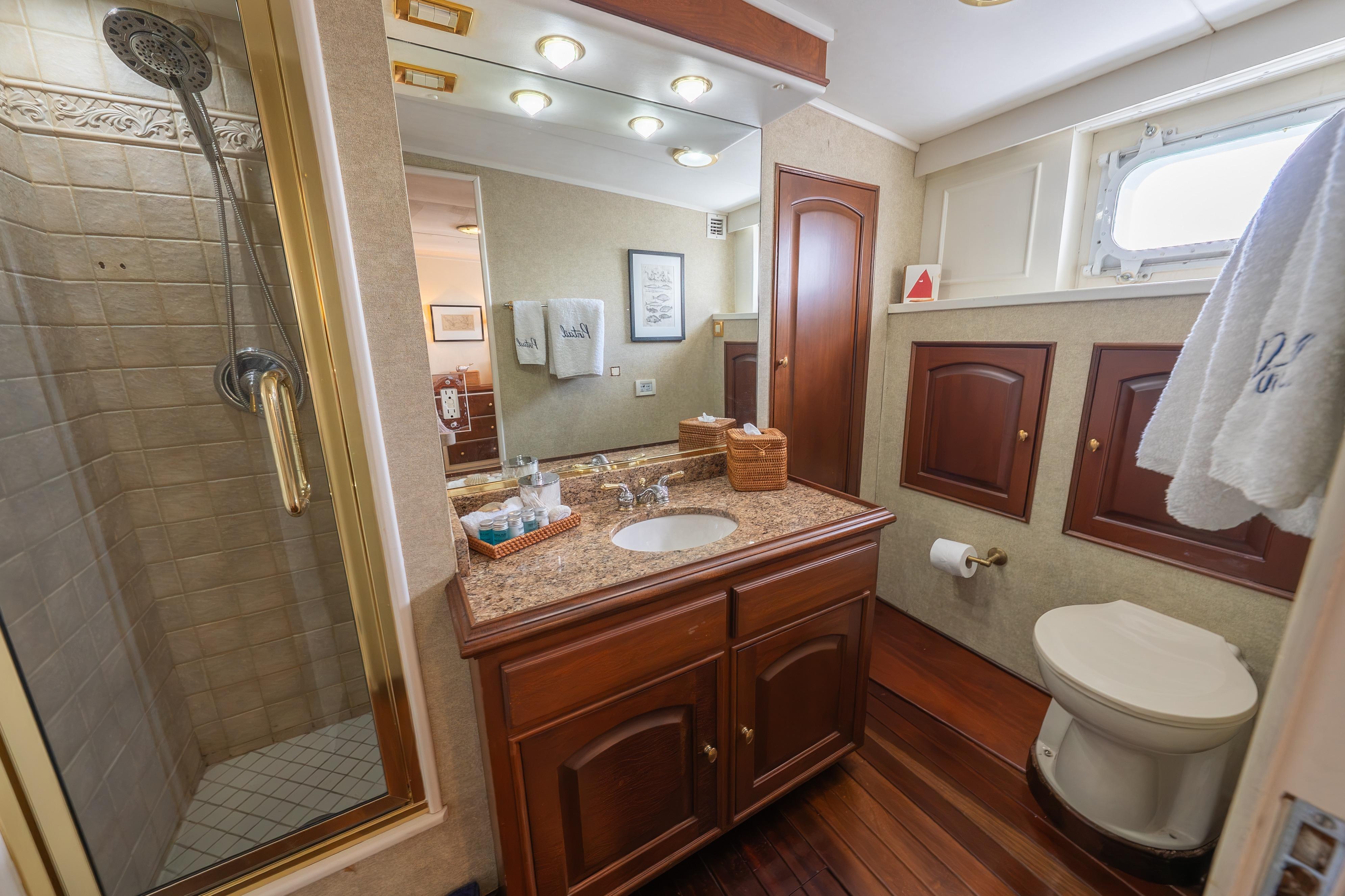 Luxurious 1963 Trumpy Classic yacht bathroom with wooden cabinetry and elegant fixtures.