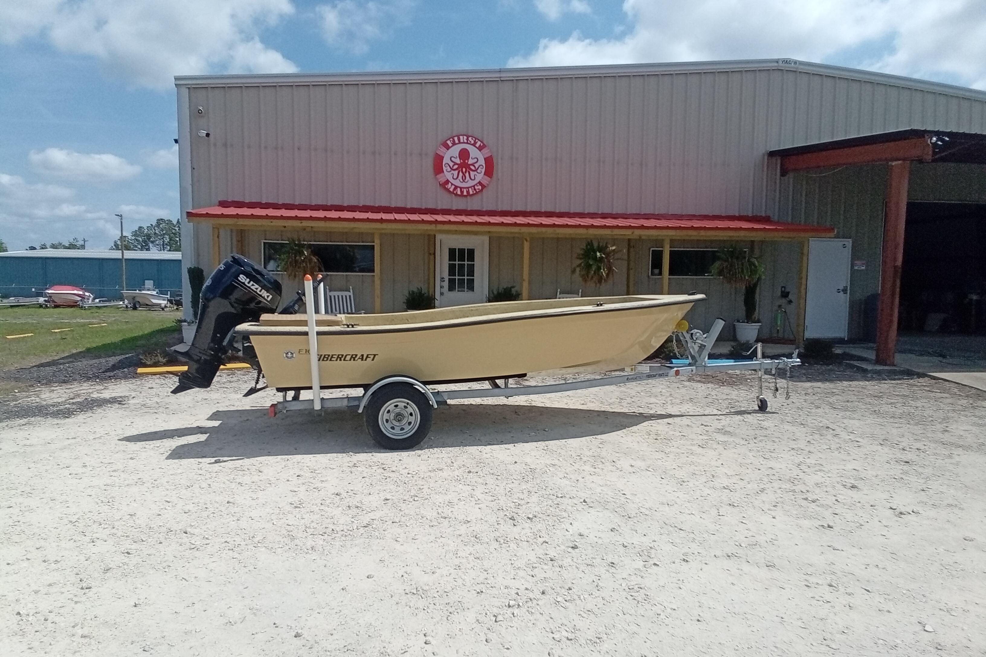 2025 Fibercraft F16 boat on trailer outside a building with red roof.