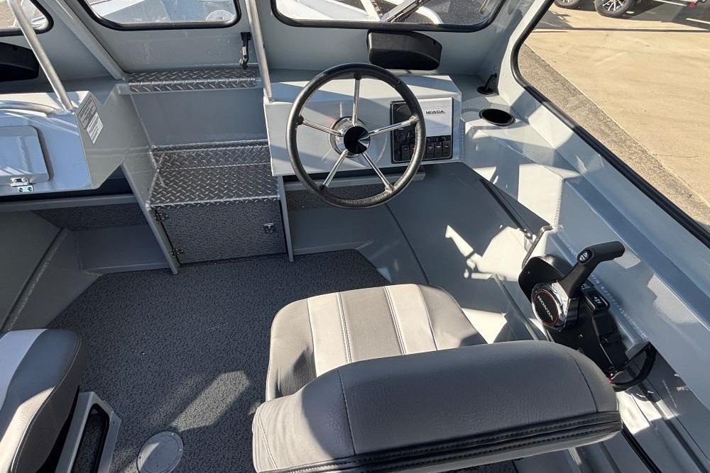 Interior of 2025 Hewescraft 200 ProV ET boat, featuring steering wheel and controls.
