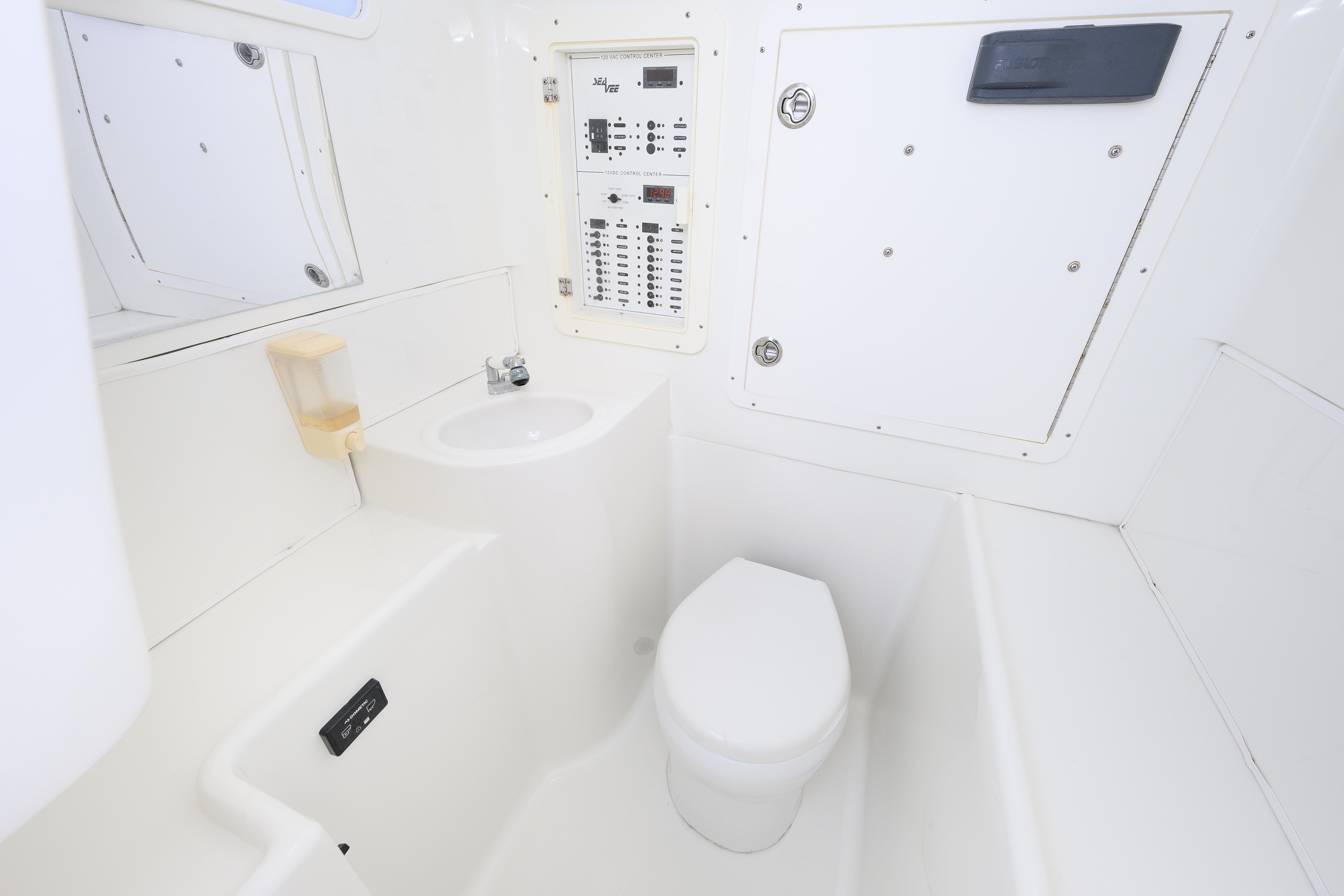 2017 SeaVee 390Z boat interior bathroom with toilet, sink, and control panel.