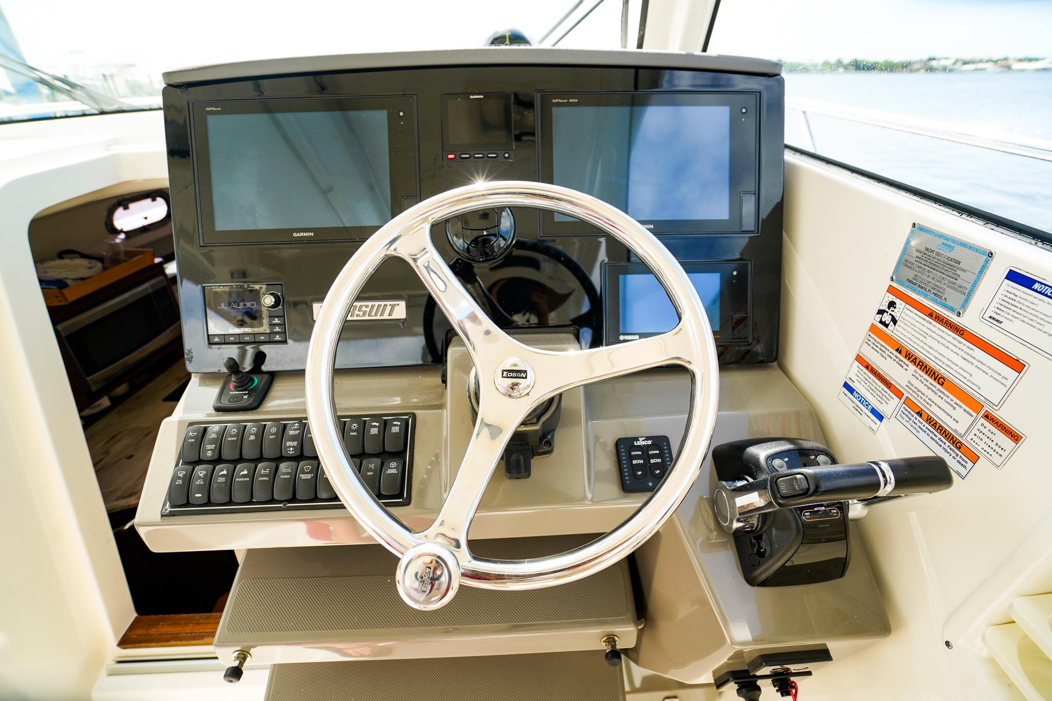 Helm of 2020 Pursuit OS 325 Offshore boat with modern controls and navigation screens.