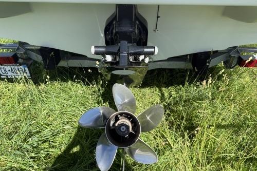 Rear view of a 2012 Crownline 215 SS boat with propeller on grass.