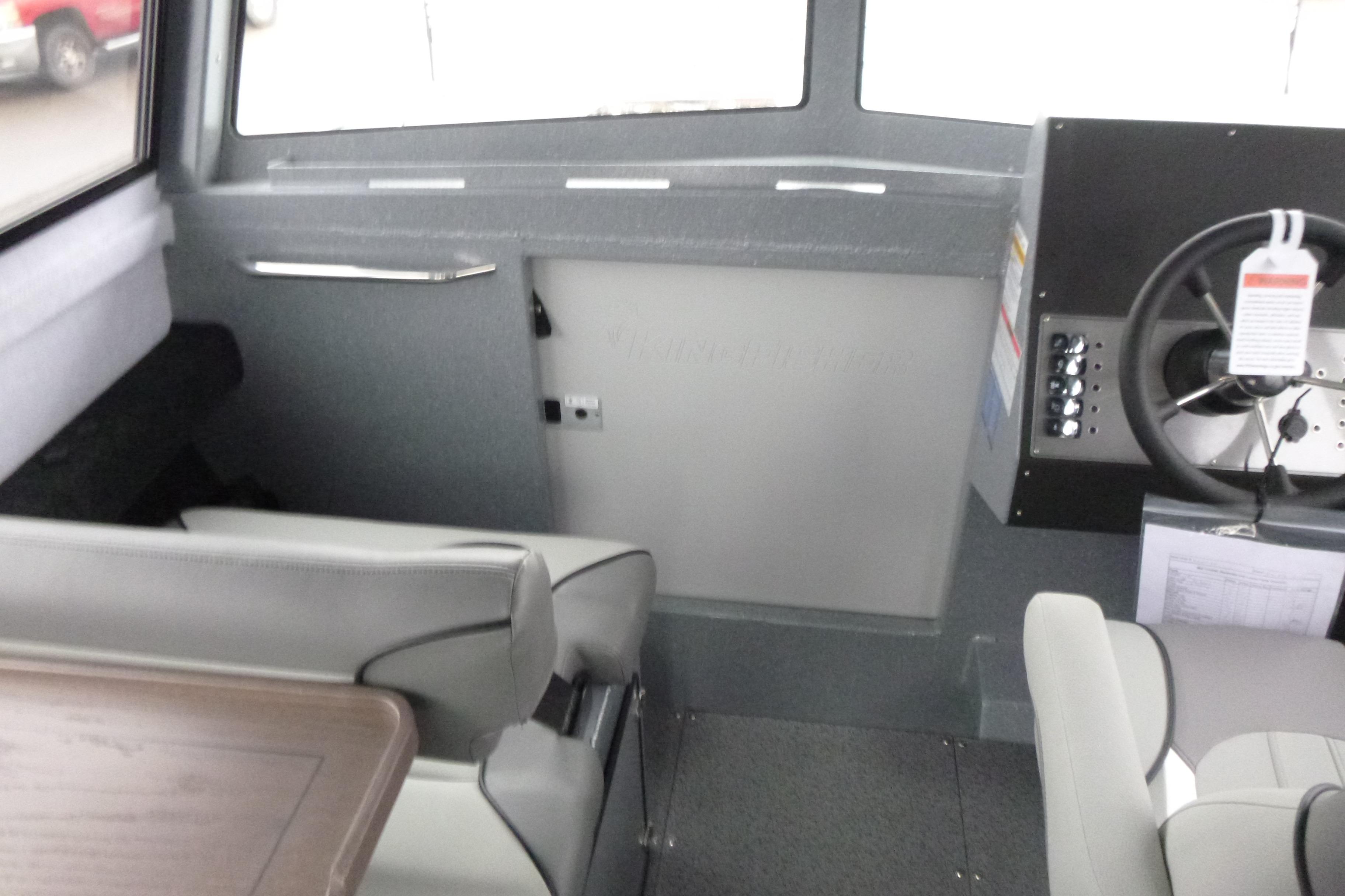 Interior of 2026 KingFisher 25 XAC boat, featuring steering wheel and seating area.