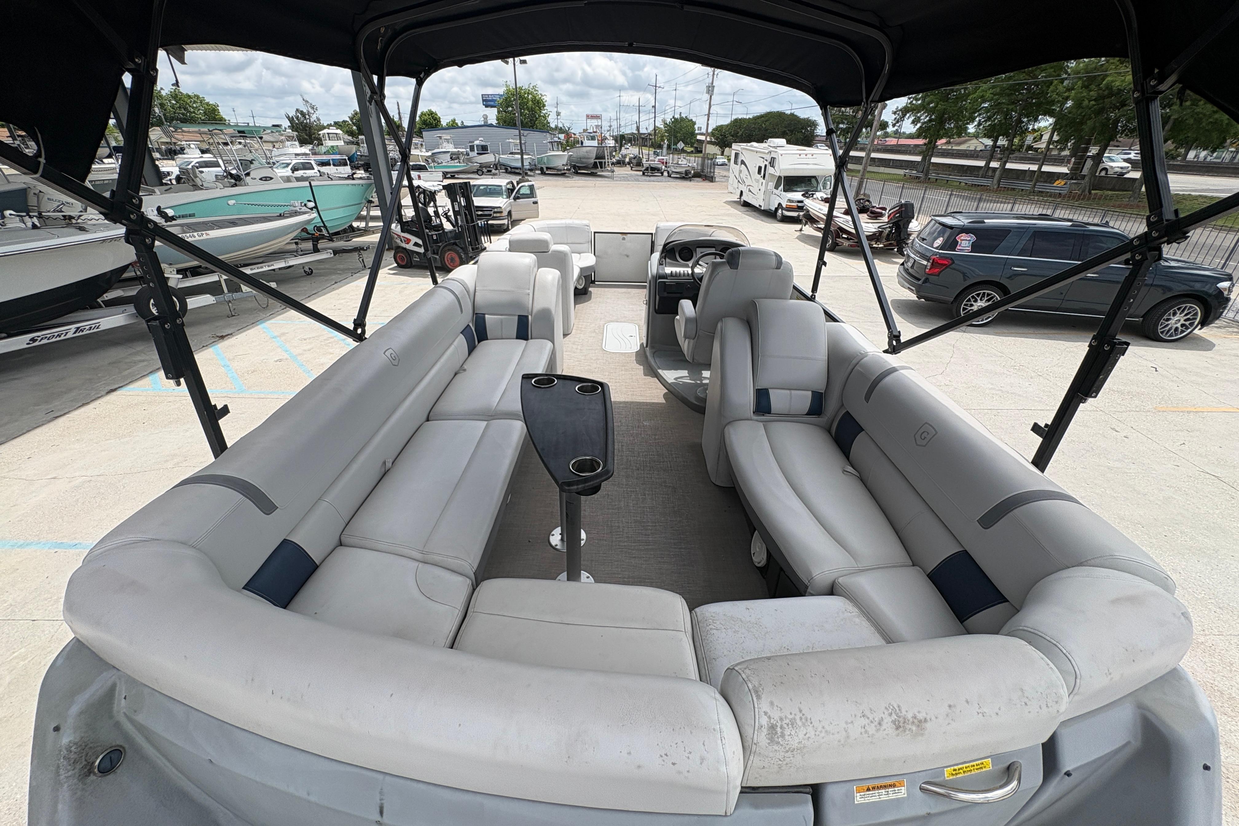 2019 Godfrey Aqua Patio pontoon boat with spacious seating and canopy, parked in a marina.