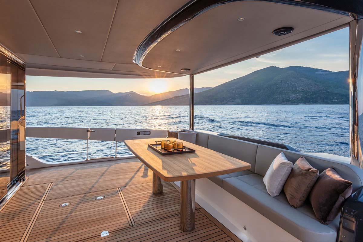 Manufacturer Provided Image: Luxury deck of 2022 Absolute 64 Navetta yacht at sunset, with scenic ocean and mountain views.