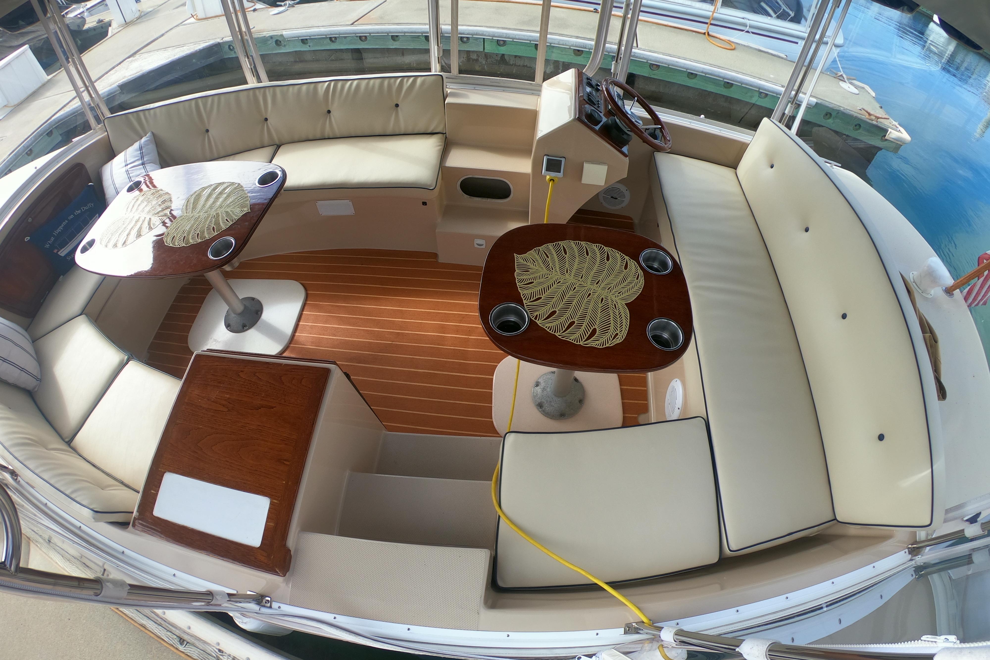 Interior of 2008 Duffy Snug Harbor 18 boat with elegant seating and wooden tables.