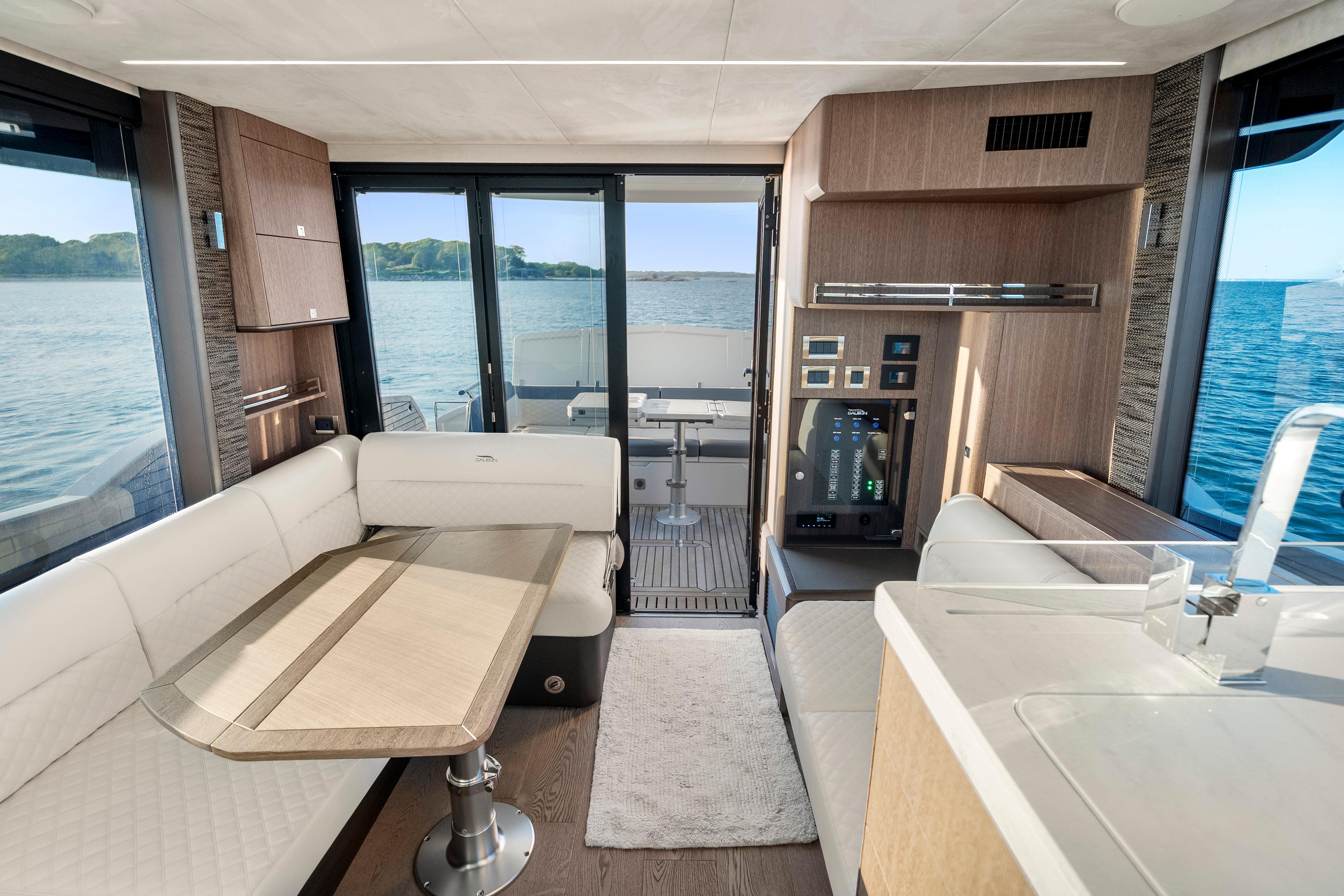 Luxurious interior of 2023 Galeon 400 Fly yacht with elegant seating and scenic ocean view.