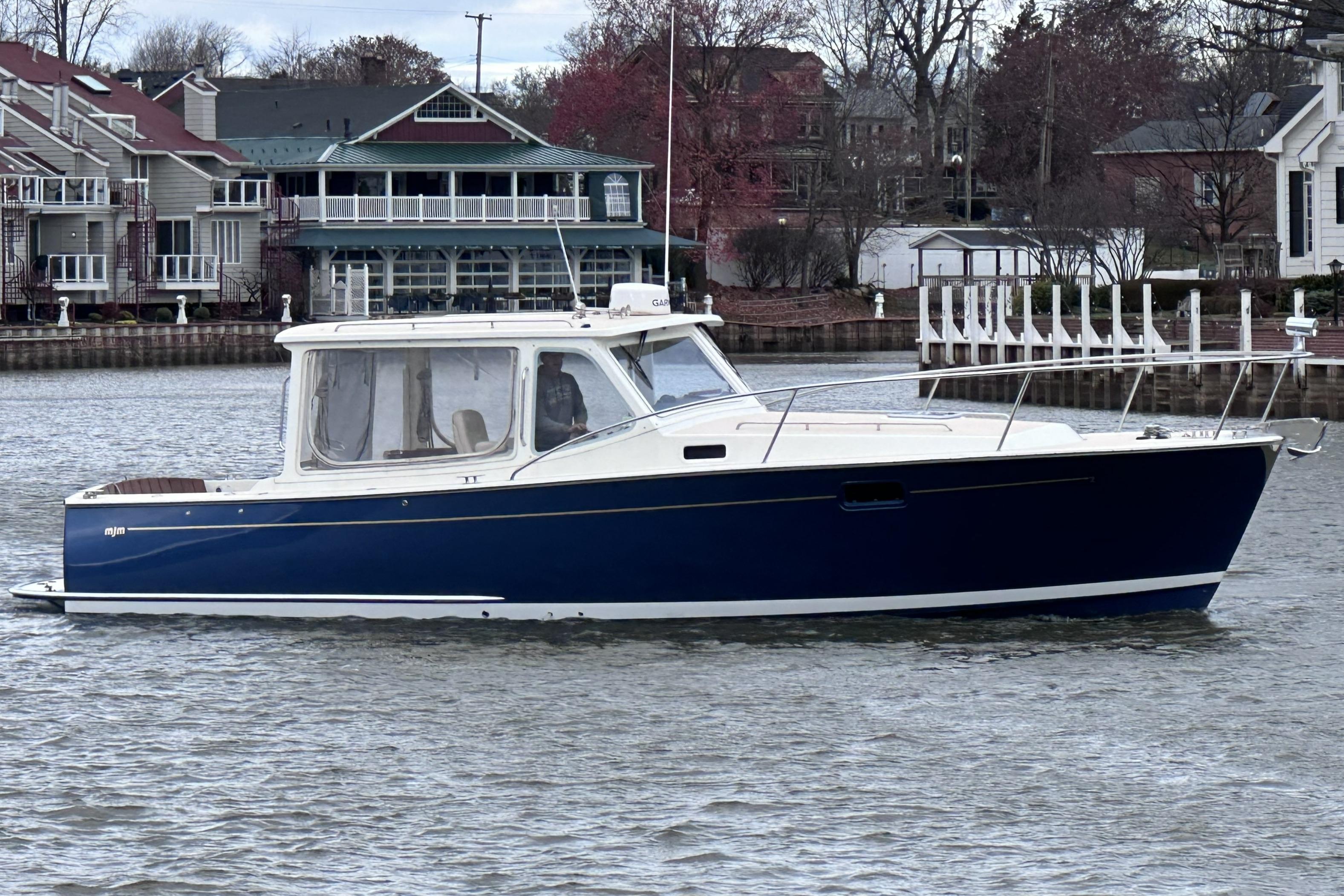 2008 MJM 34z Downeast boat on calm water near waterfront homes.