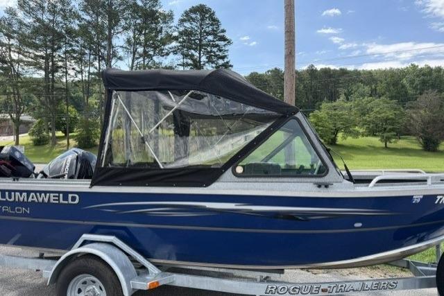 2023 Alumaweld Talon 18 boat on trailer, featuring a blue exterior and canopy.