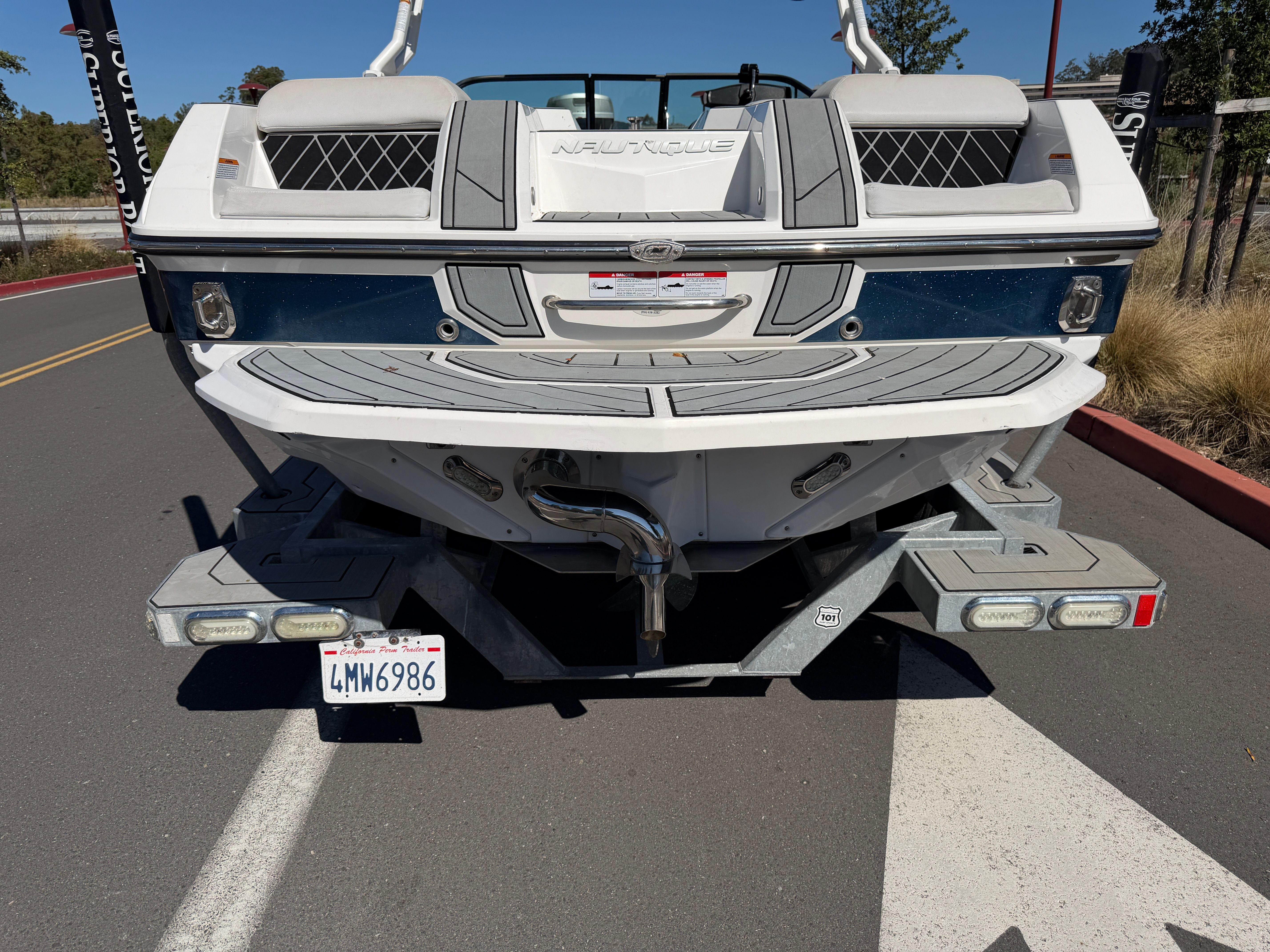 The image shows the rear of a white 2018 Nautique Super Air Nautique GS22 on a trailer.