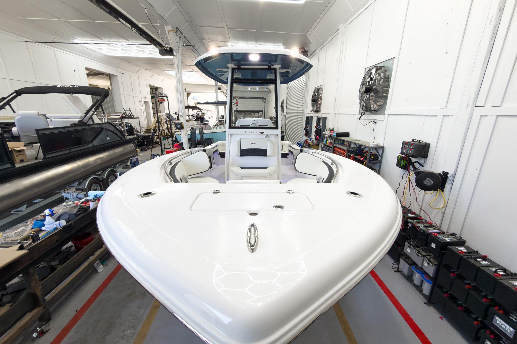 A Tidewater 220 LXF boat in a workshop, surrounded by tools and equipment.