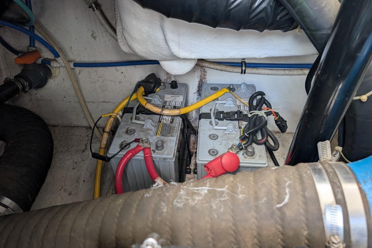 Battery compartment of a 2000 Pursuit 3400 Express boat with cables and connections.