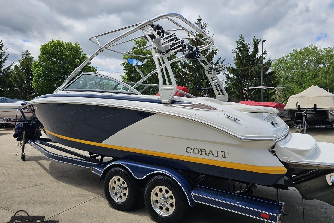 2010 Cobalt 232 WSS boat on trailer, parked outdoors under cloudy sky.