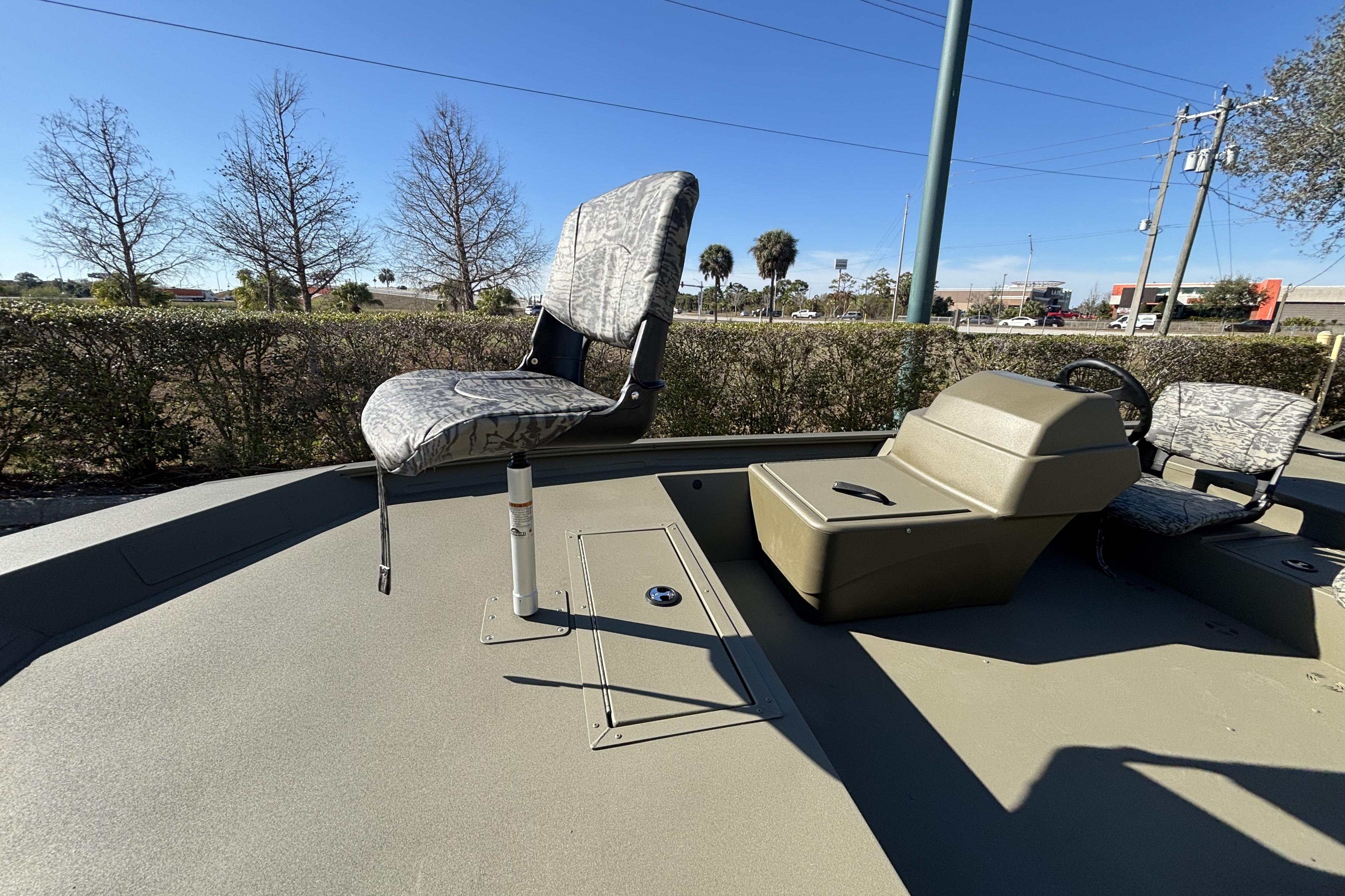 2026 Tracker Grizzly 1754 SC boat interior with seating and console, outdoors.