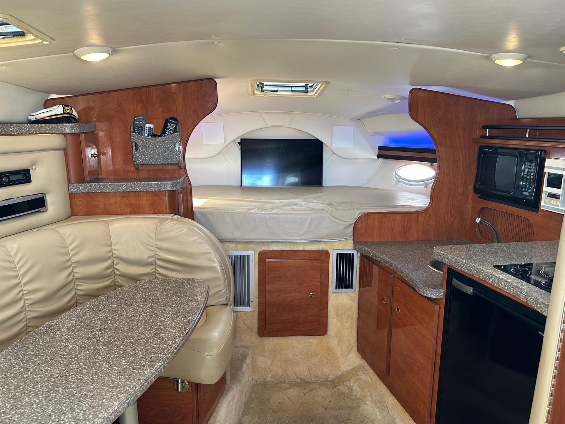 Interior of 2004 Rinker Fiesta Vee 312 boat with kitchenette and seating area.