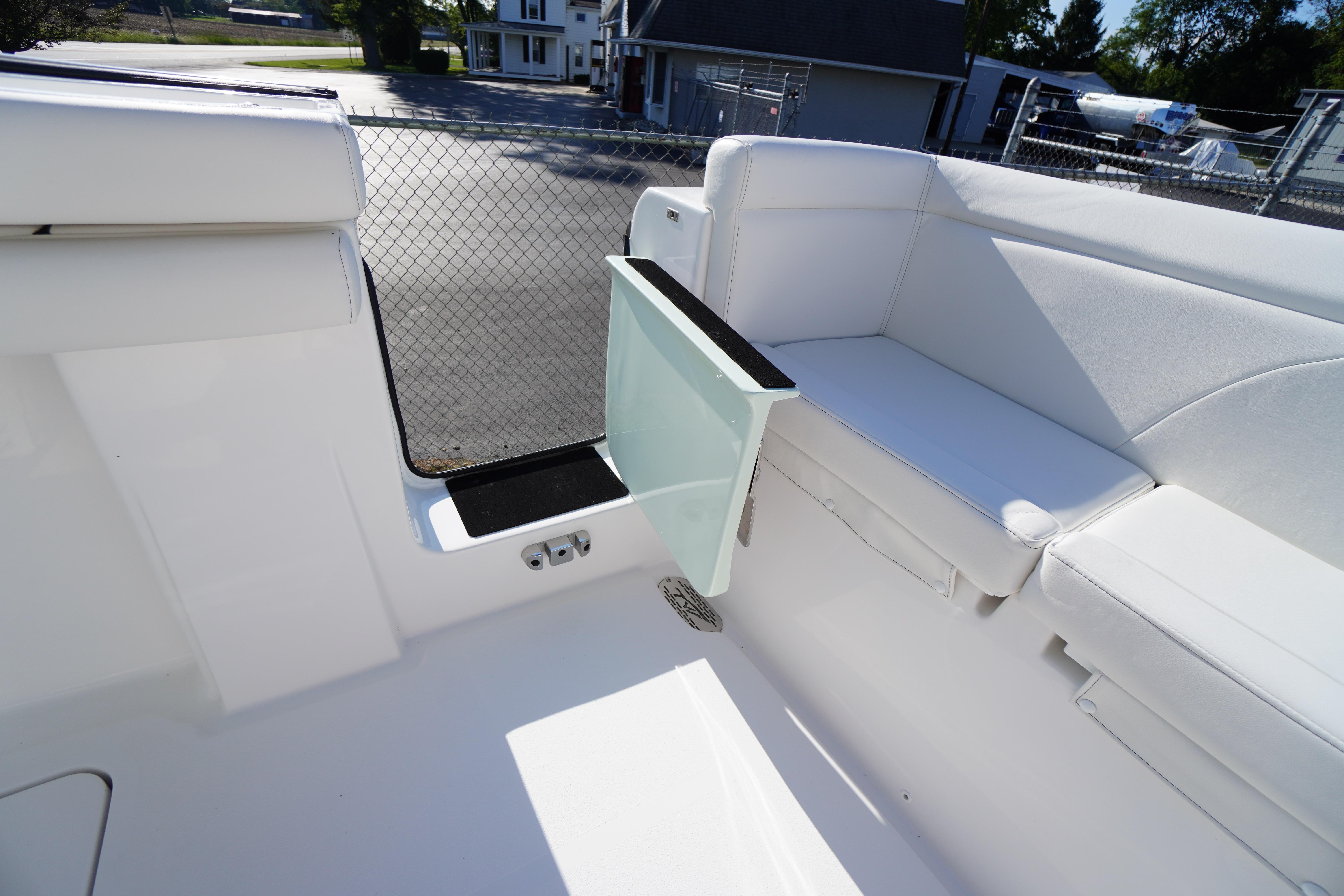 2026 Tidewater 272 LXF boat interior with white seating and open side door.