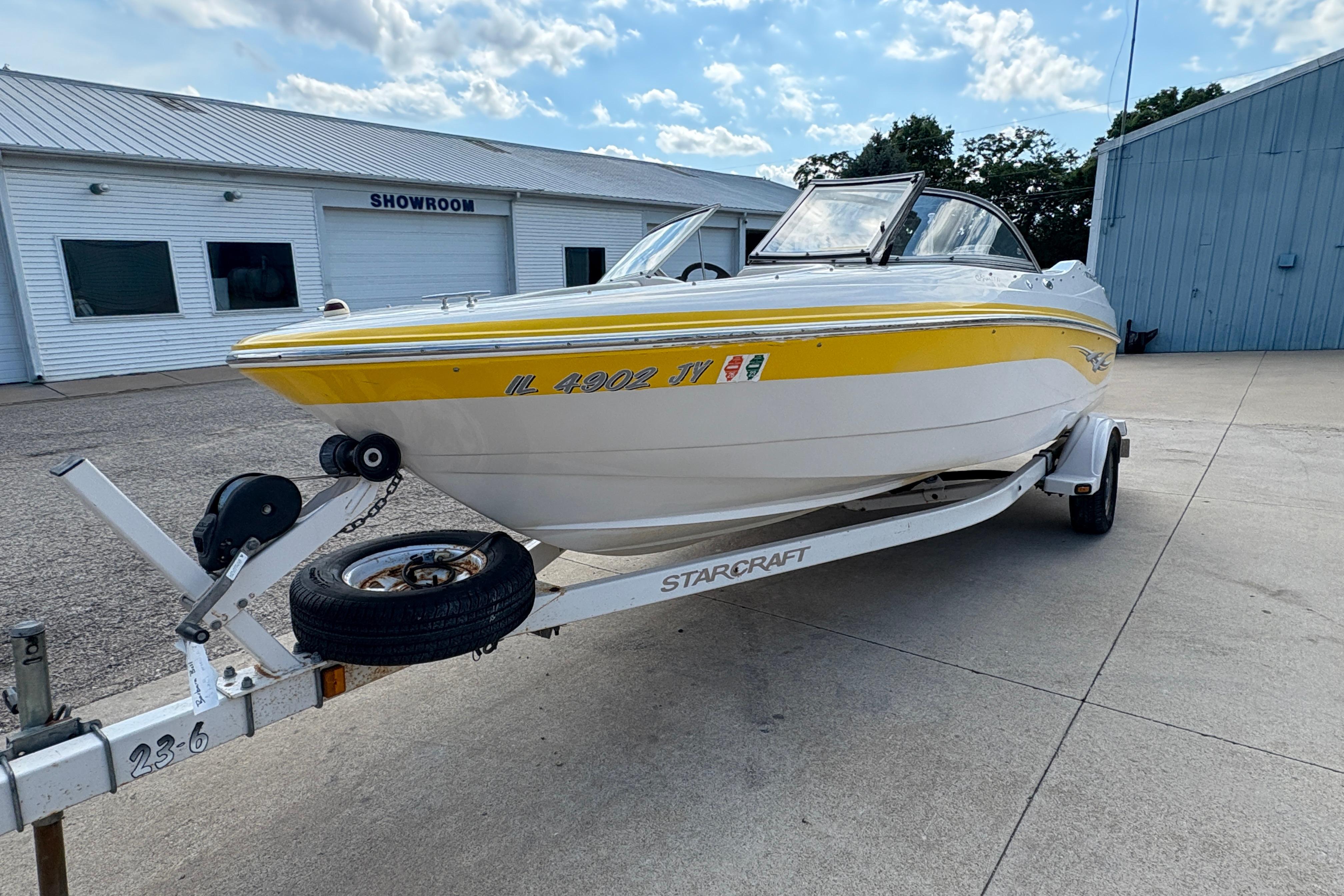 2005 Starcraft C-Star 1700 OB boat on trailer, parked outside showroom.