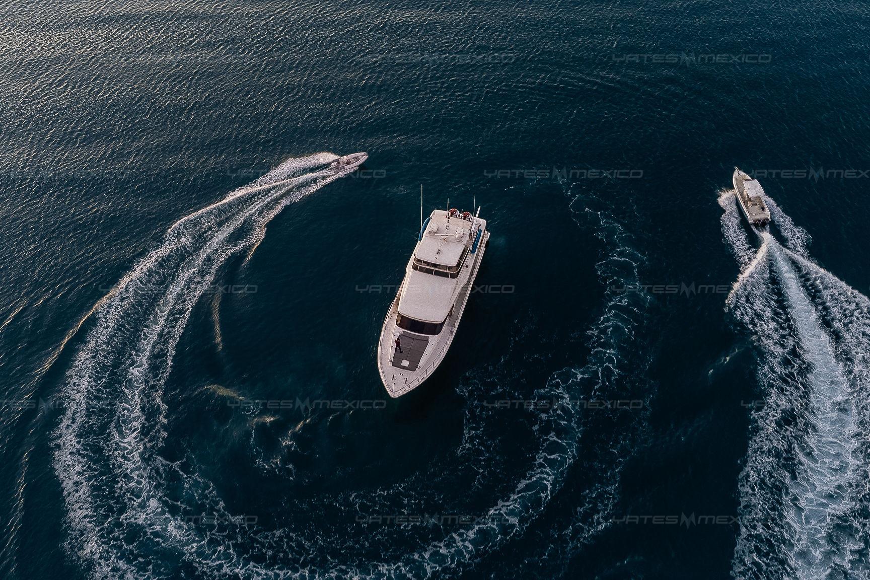 Aerial view of Bravo 82 yacht, 2002 model, cruising with two smaller boats in open water.