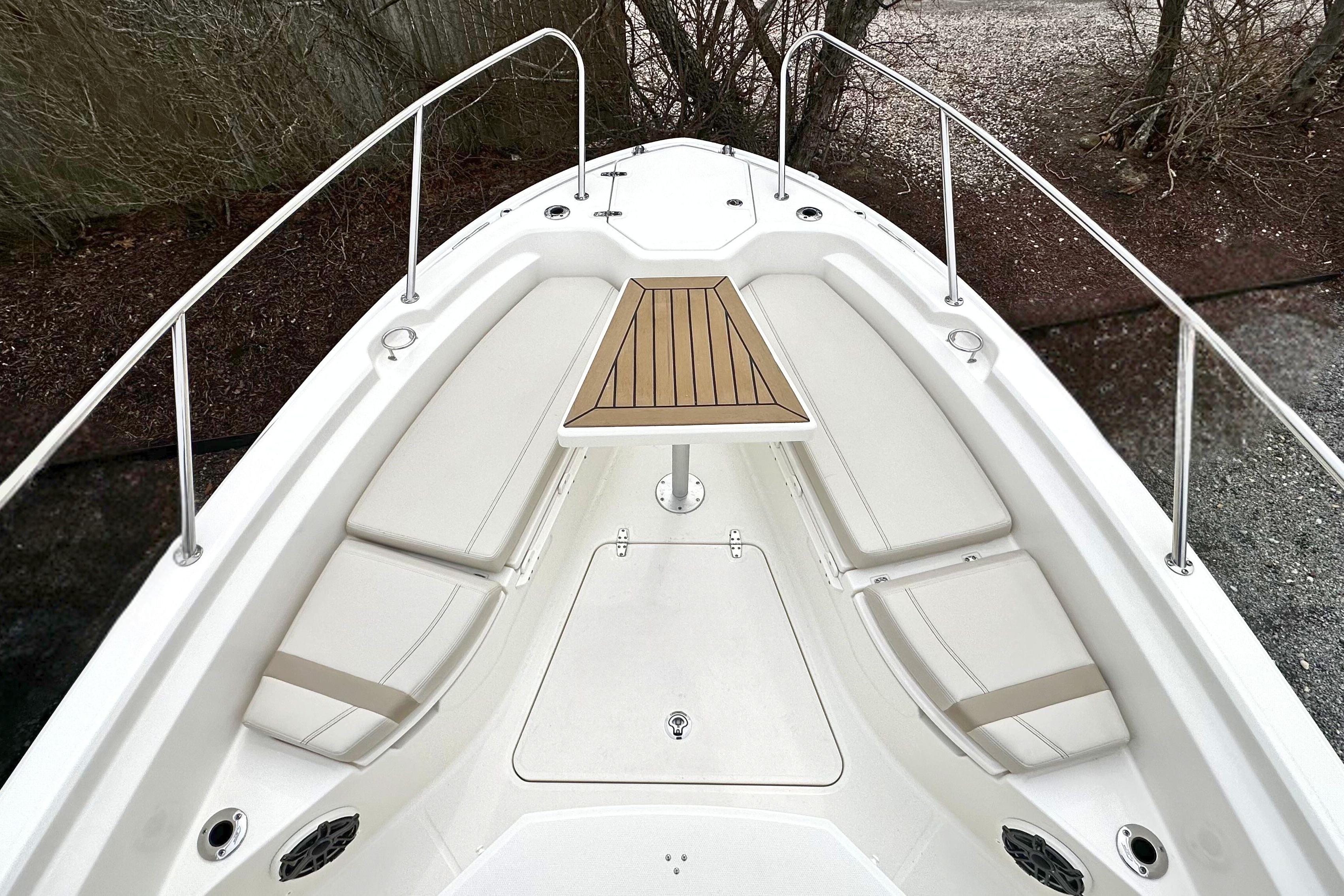 2026 Boston Whaler 280 Dauntless boat interior with cushioned seating and wooden table.