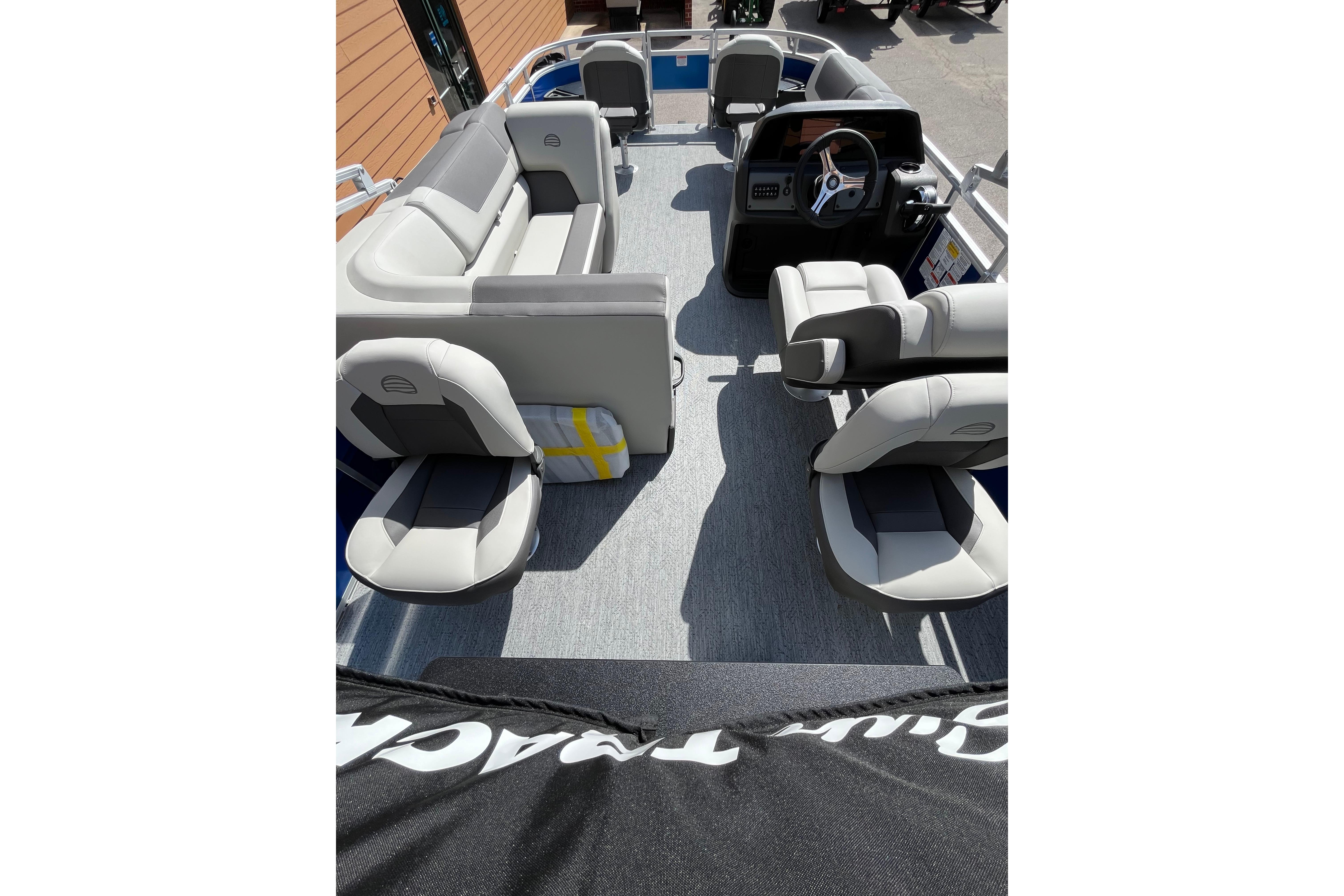 Interior view of 2026 Sun Tracker Fishin' Barge 20 DLX pontoon boat with seating and helm.