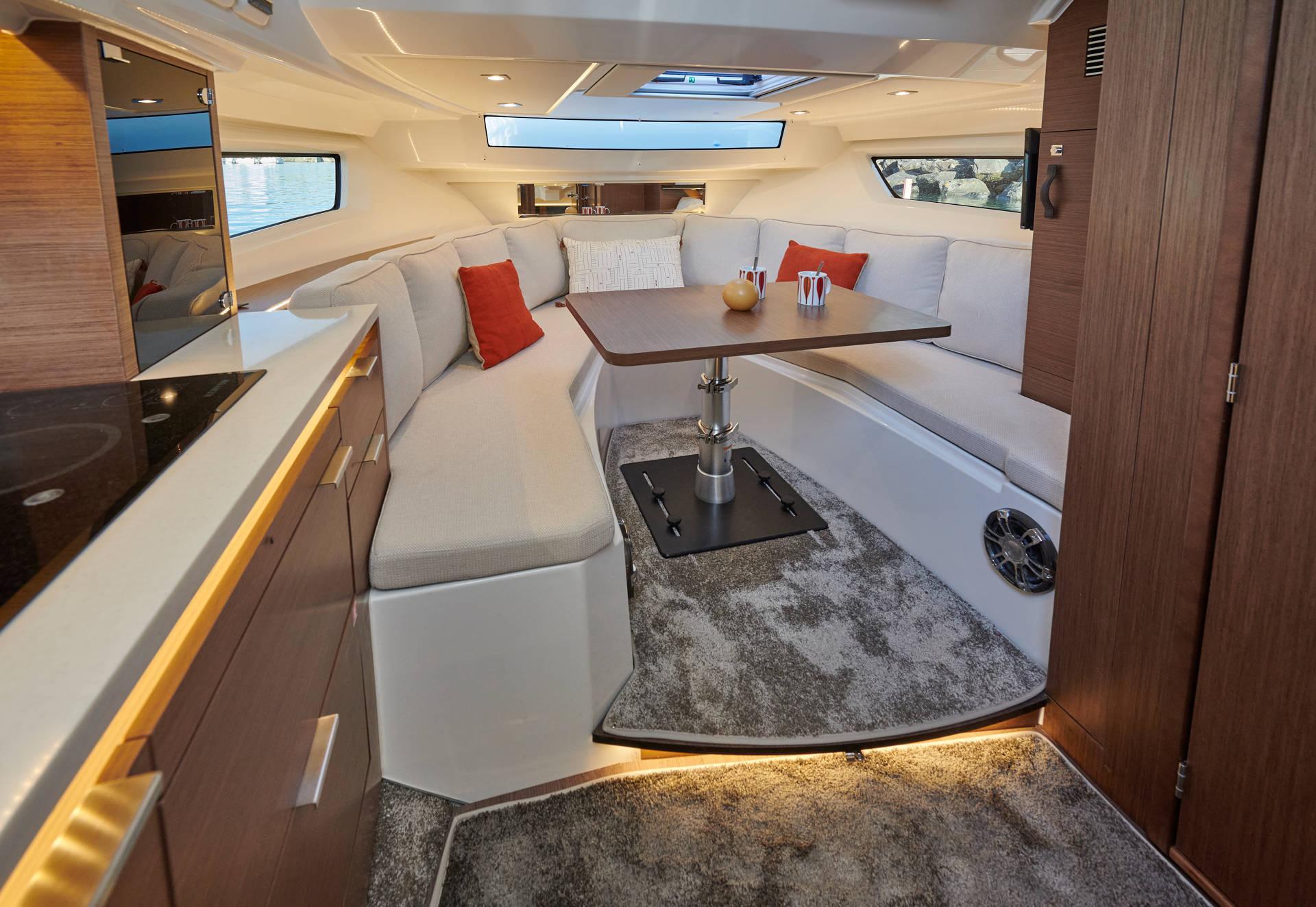2024 Jeanneau 10.5 WA interior with modern seating, table, and stylish decor.