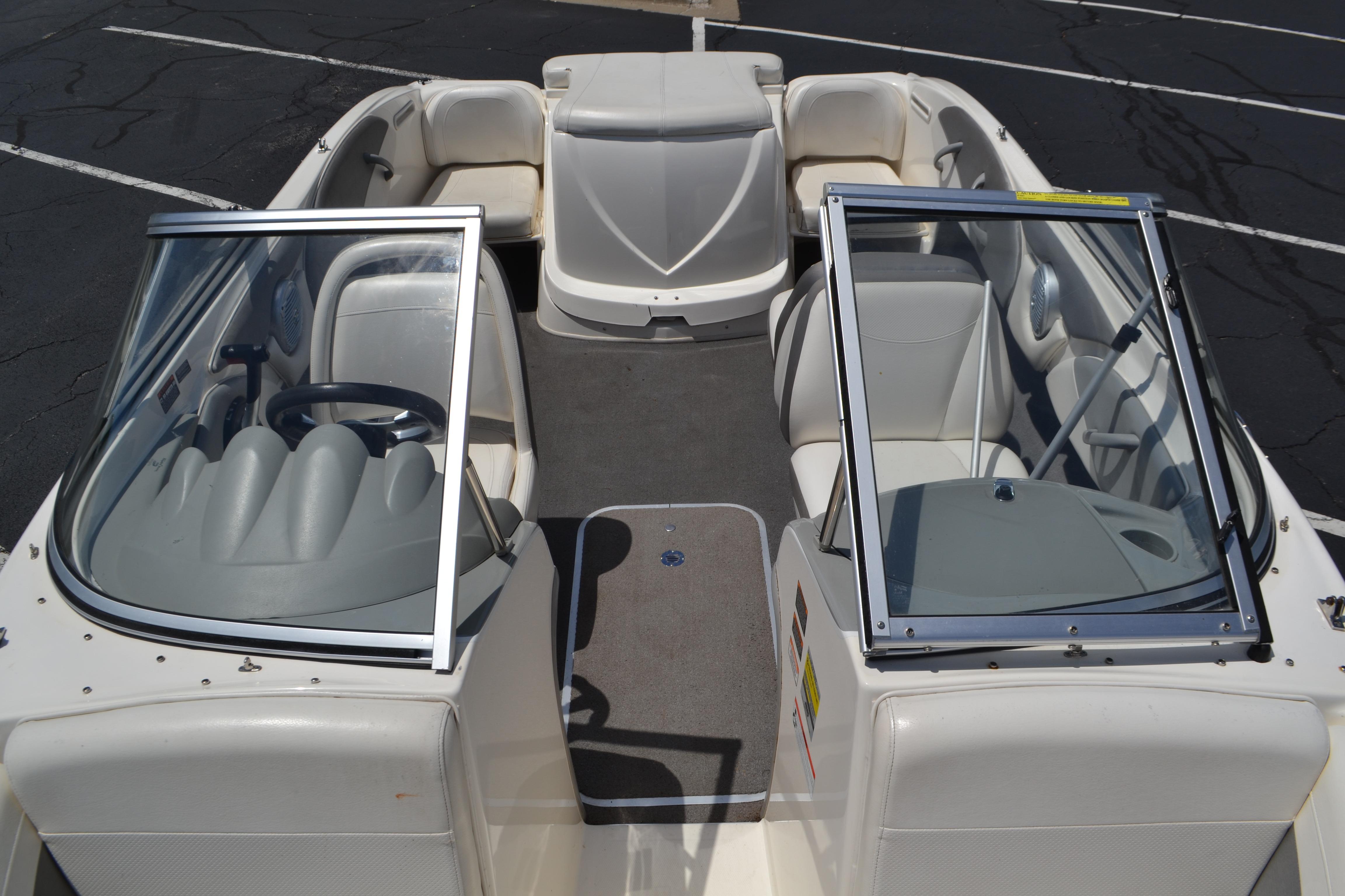 2009 Bayliner 185 Bowrider interior with seating and steering wheel, parked on asphalt.