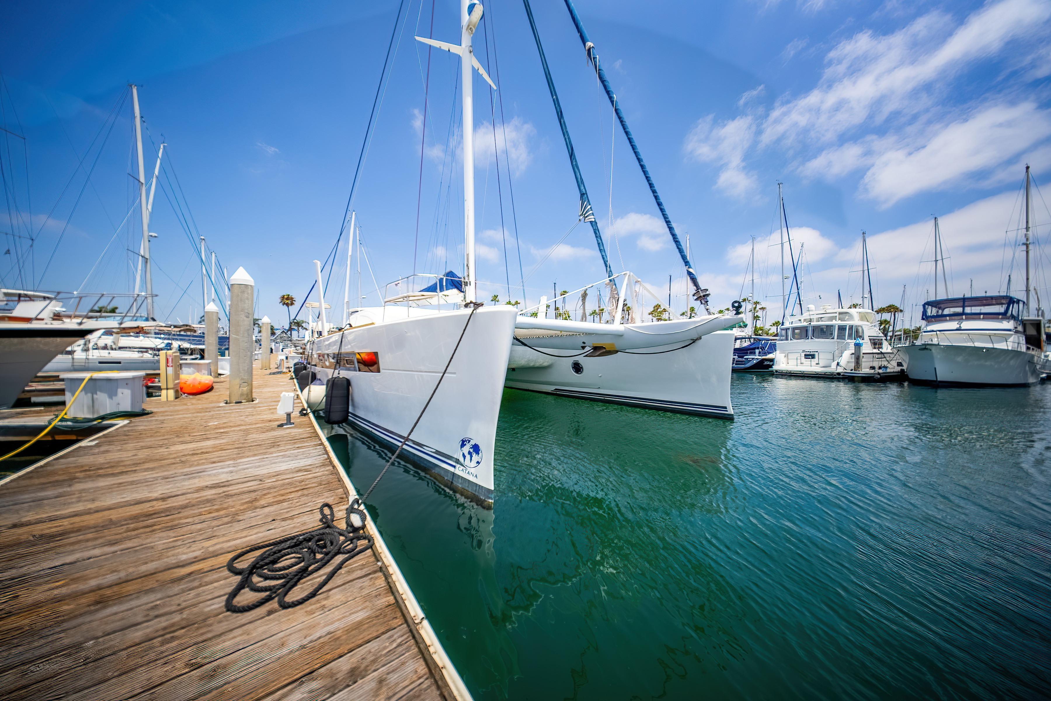 Docked 2009 Catana 65 catamaran in marina under blue sky.