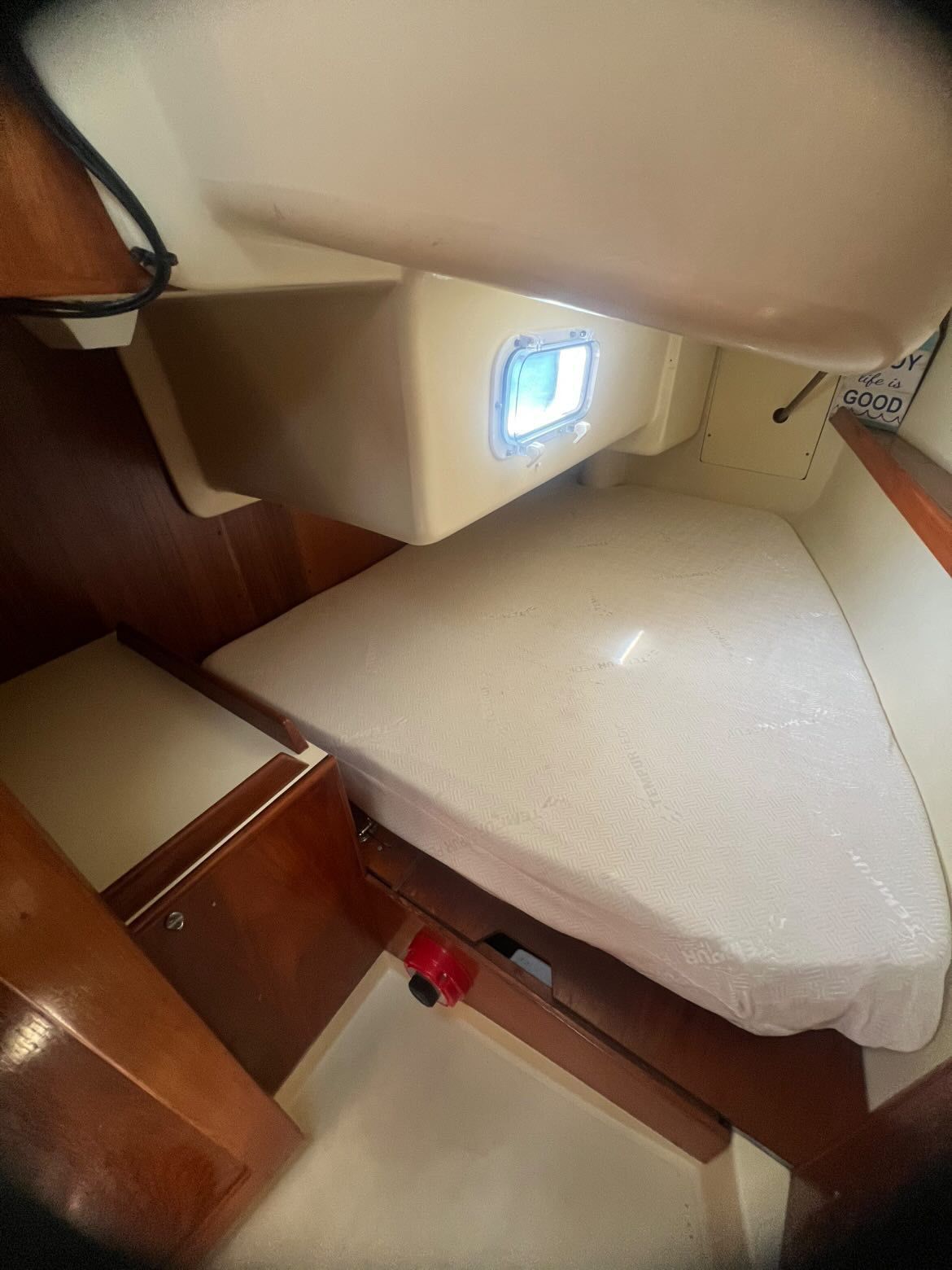 Interior of a 1988 Pearson 28 with a bed and a porthole.