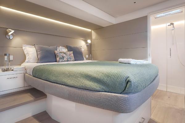 Luxurious bedroom interior of 2025 Lagoon SIXTY 5 yacht with modern design and cozy bedding.