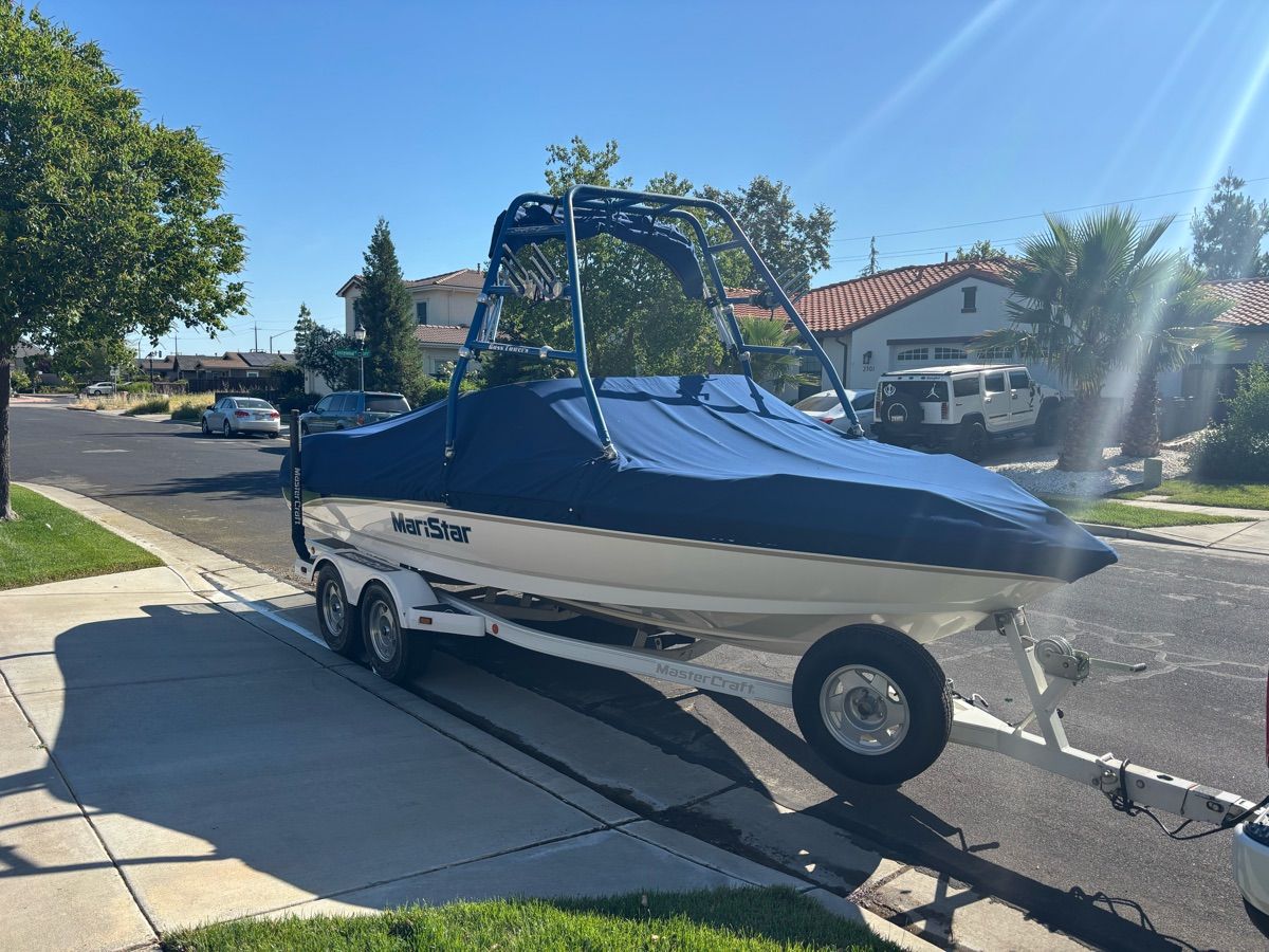 A 2000 MasterCraft MariStar 210 on a trailer in a residential street.