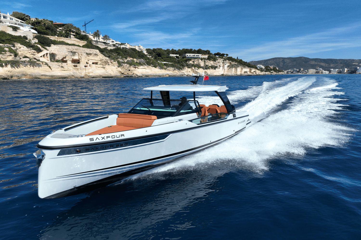A 2027 Saxdor SX320 GTO speeds across blue water, surrounded by coastal scenery.