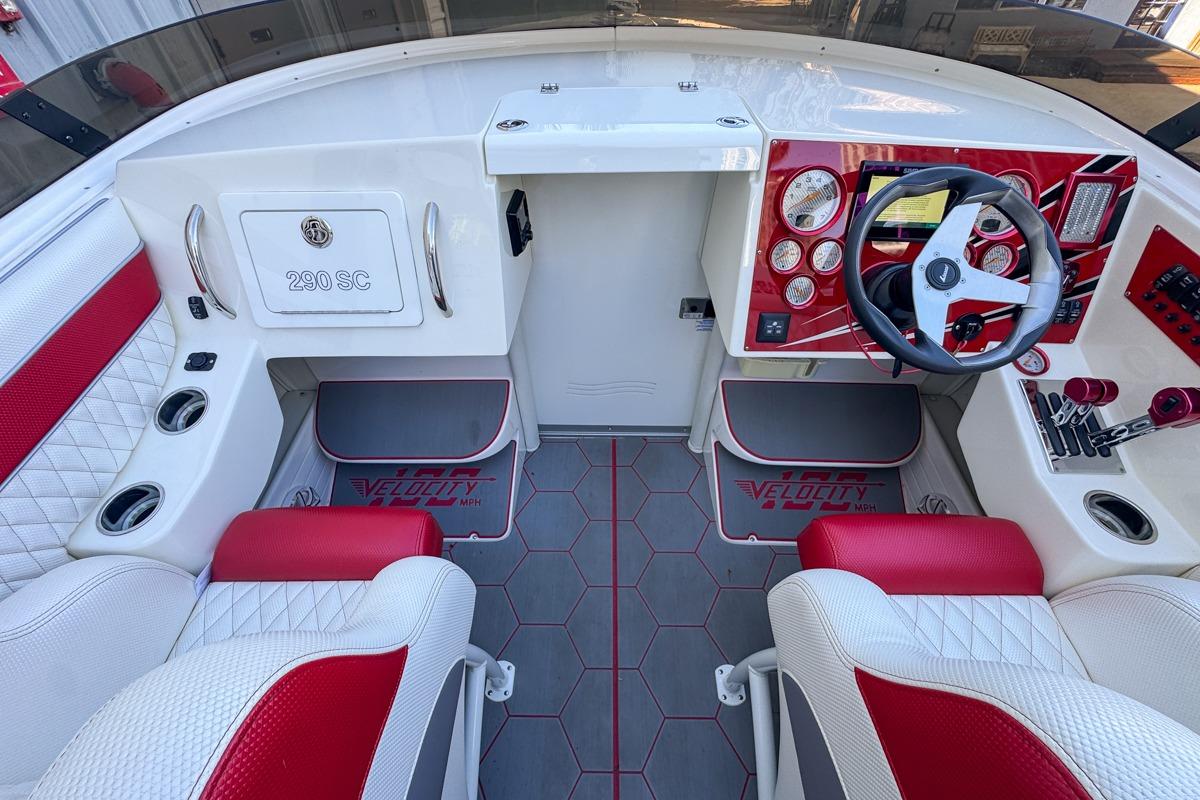2022 Velocity 290sc boat interior with red and white seating, modern dashboard, and steering wheel.