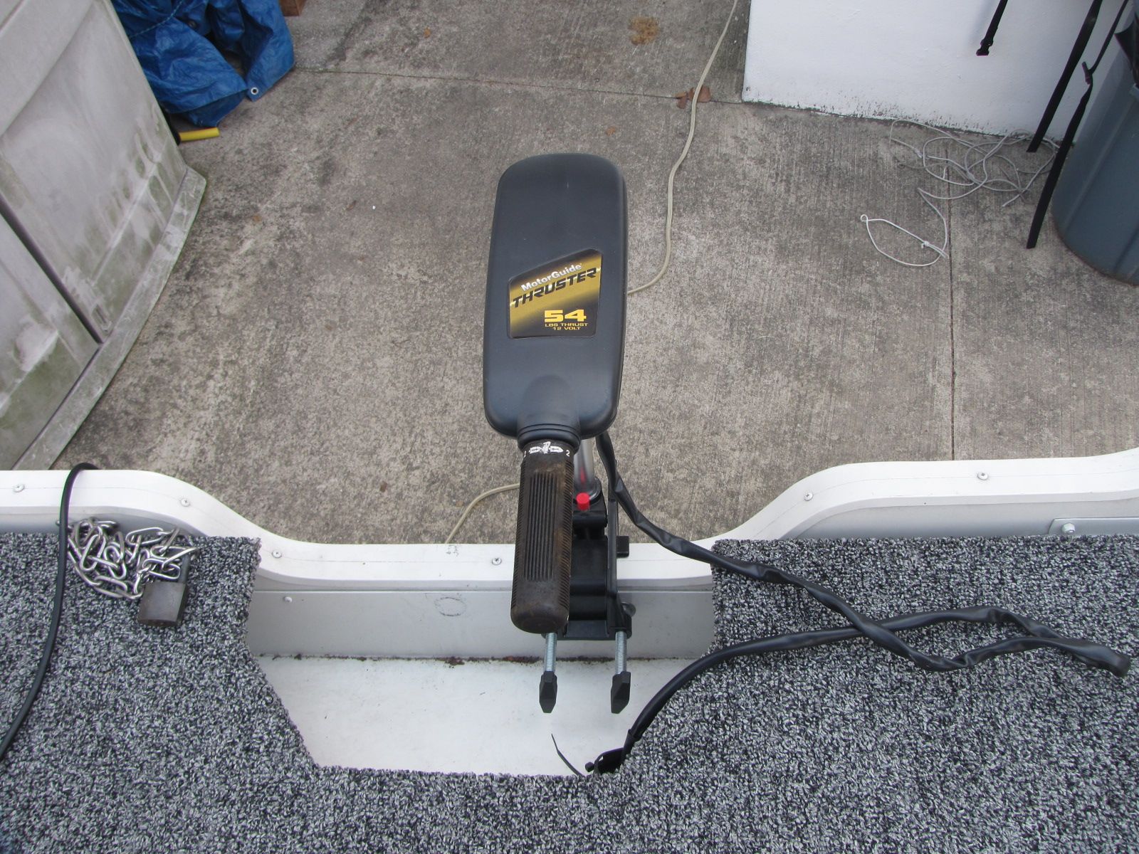 Close-up of a boat motor with gray carpeted flooring.