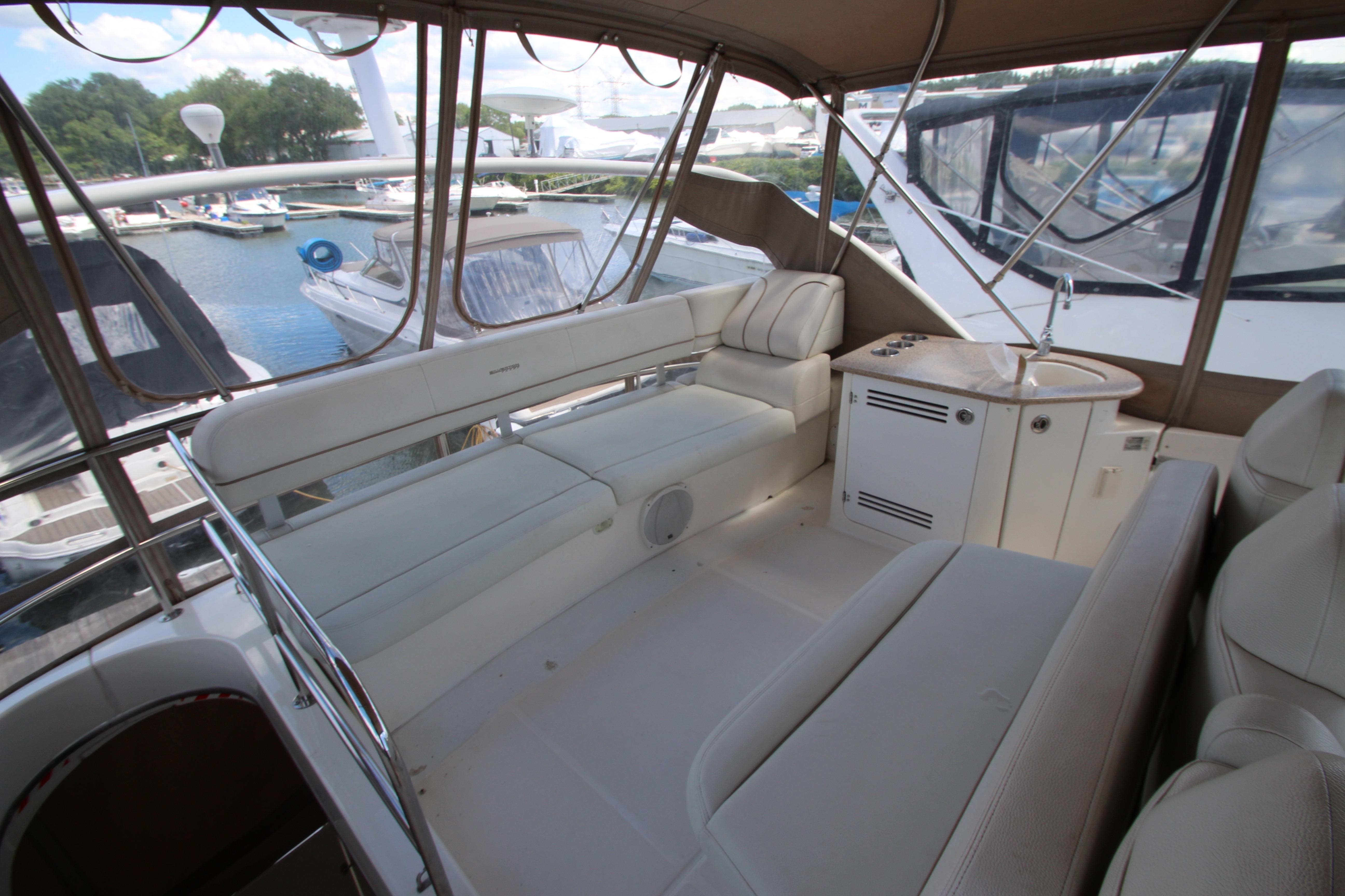 2006 Silverton 38 Sport Bridge interior with plush seating and kitchenette, docked at marina.