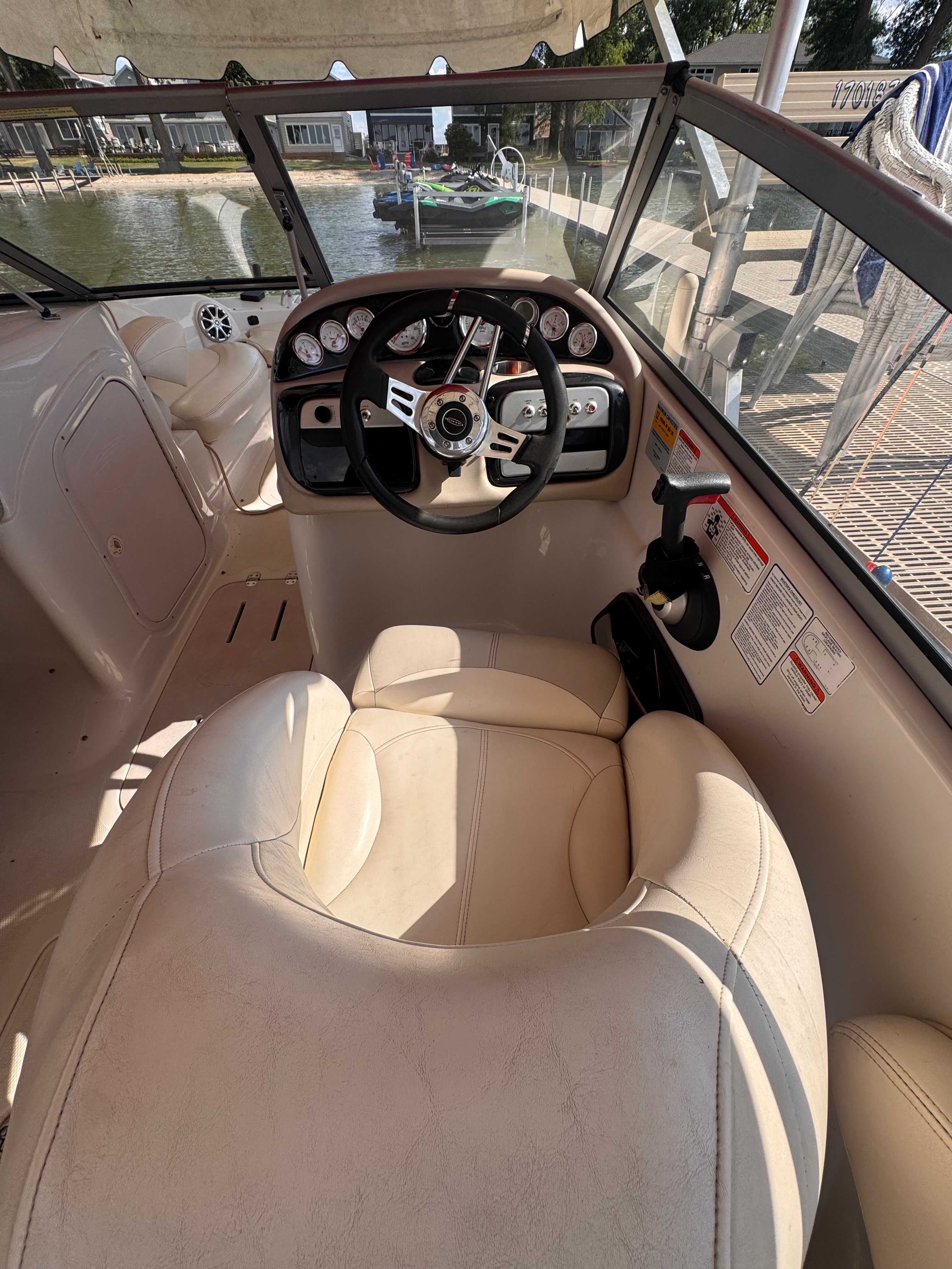 The image shows the cockpit of a 2011 Tahoe 228 boat with a sleek steering wheel and instruments.