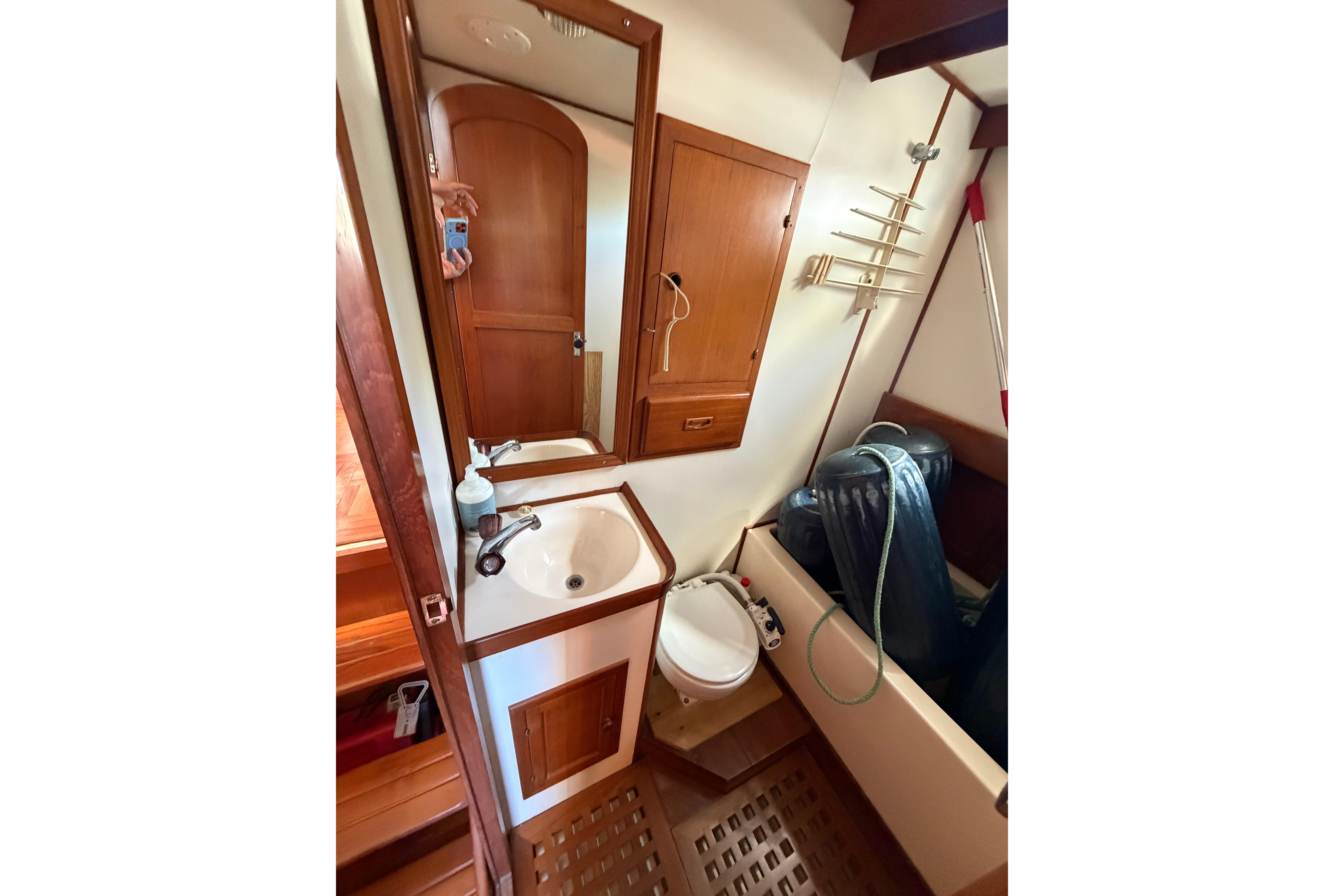 1987 Marine Trader 36 bathroom with sink, mirror, and wooden cabinetry.