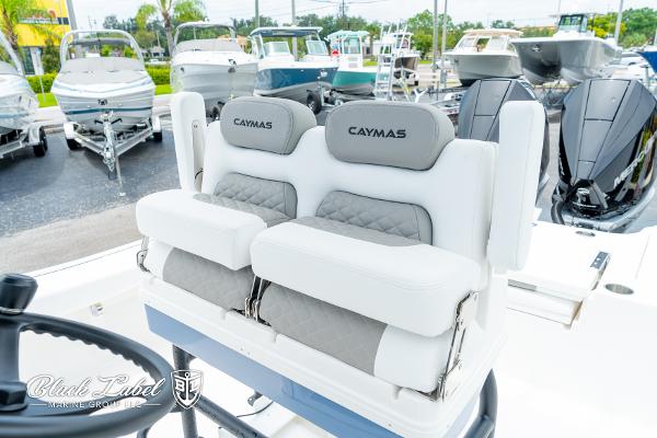 2025 Caymas 281 HB boat seats, white and gray, in a showroom with other boats.