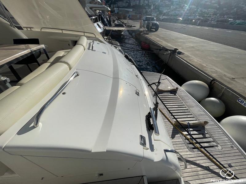 Sunseeker Manhattan 74 yacht docked at marina, showcasing sleek design and spacious deck.