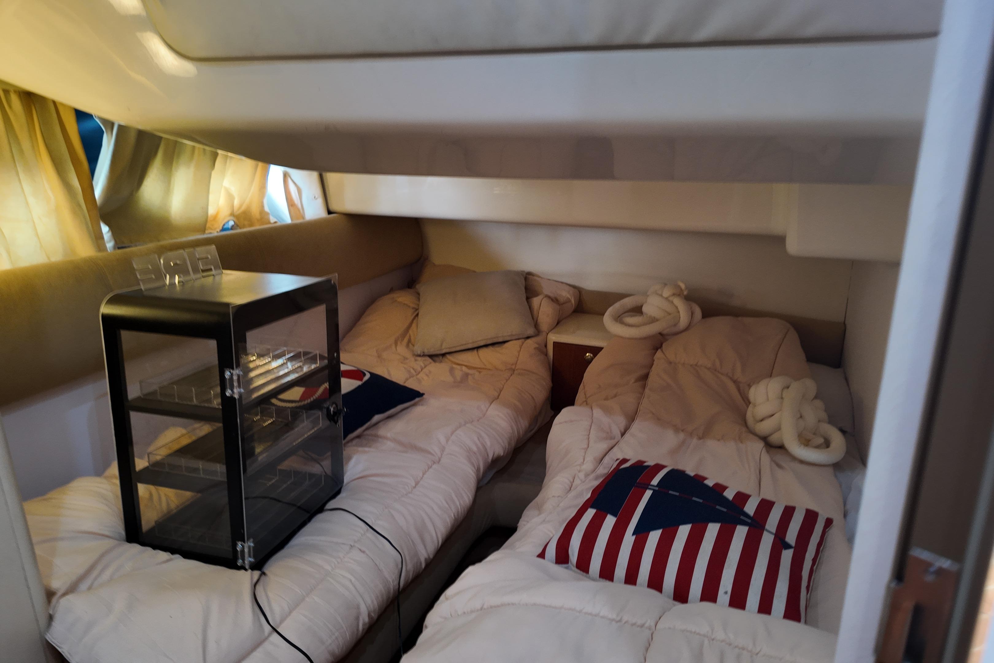 Cozy cabin interior of 2007 Cranchi Atlantique 40 yacht with twin beds and nautical decor.