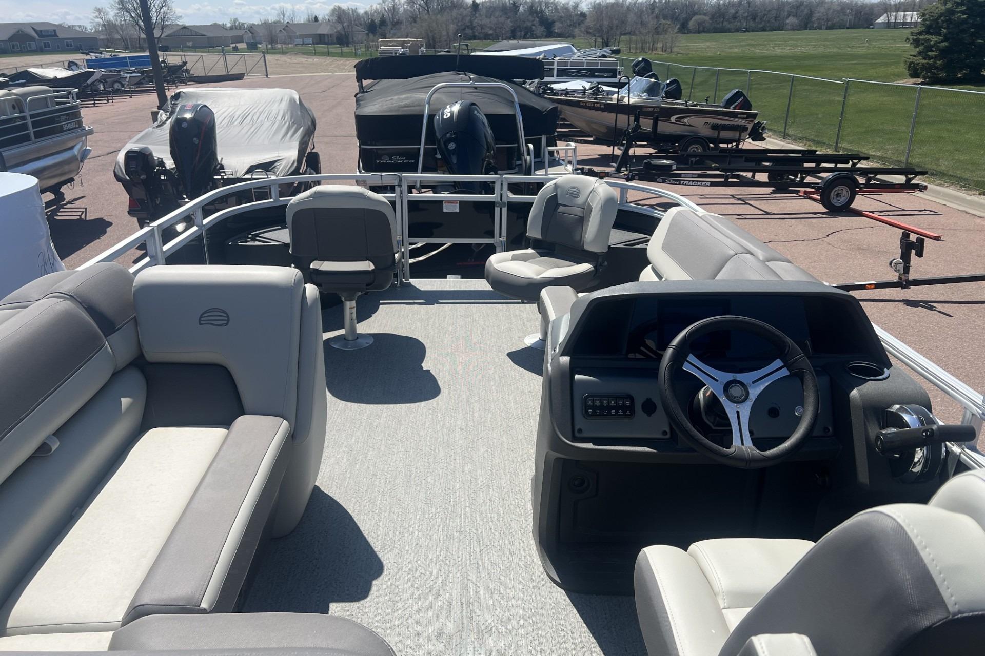 2026 Sun Tracker Fishin' Barge 20 DLX pontoon boat interior with seating and steering console.