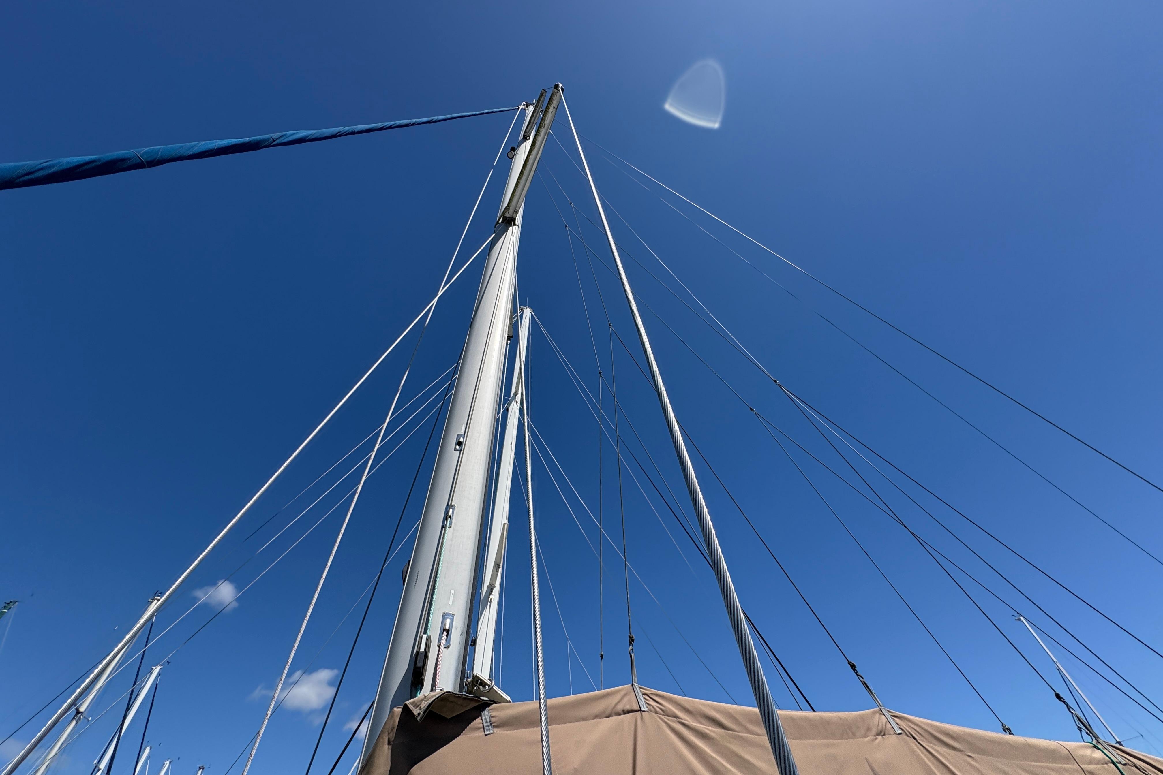 Mast and rigging of 1990 Beneteau Oceanis 500 sailboat against clear blue sky.