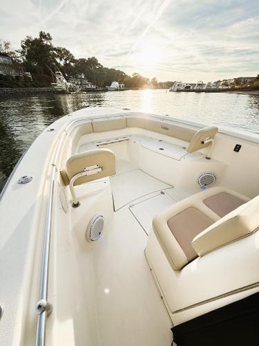 2016 Cobia 296 Center Console boat on serene water at sunset.