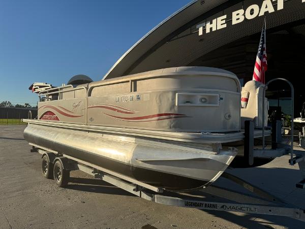 2005 Starcraft 22 Sport pontoon boat on trailer, parked outside dealership.