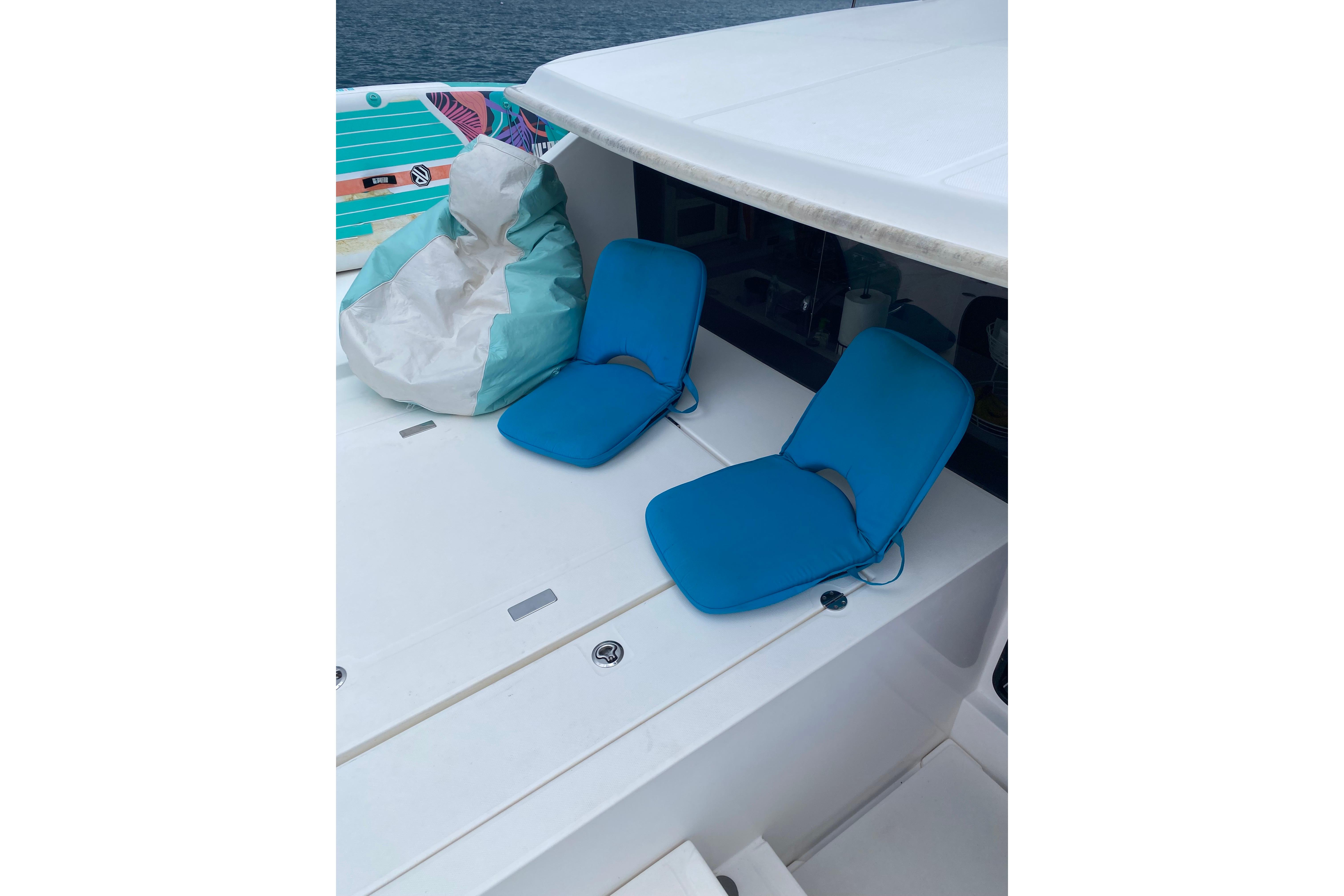 Two blue deck chairs and a bean bag on a 2017 Leopard 40 catamaran.