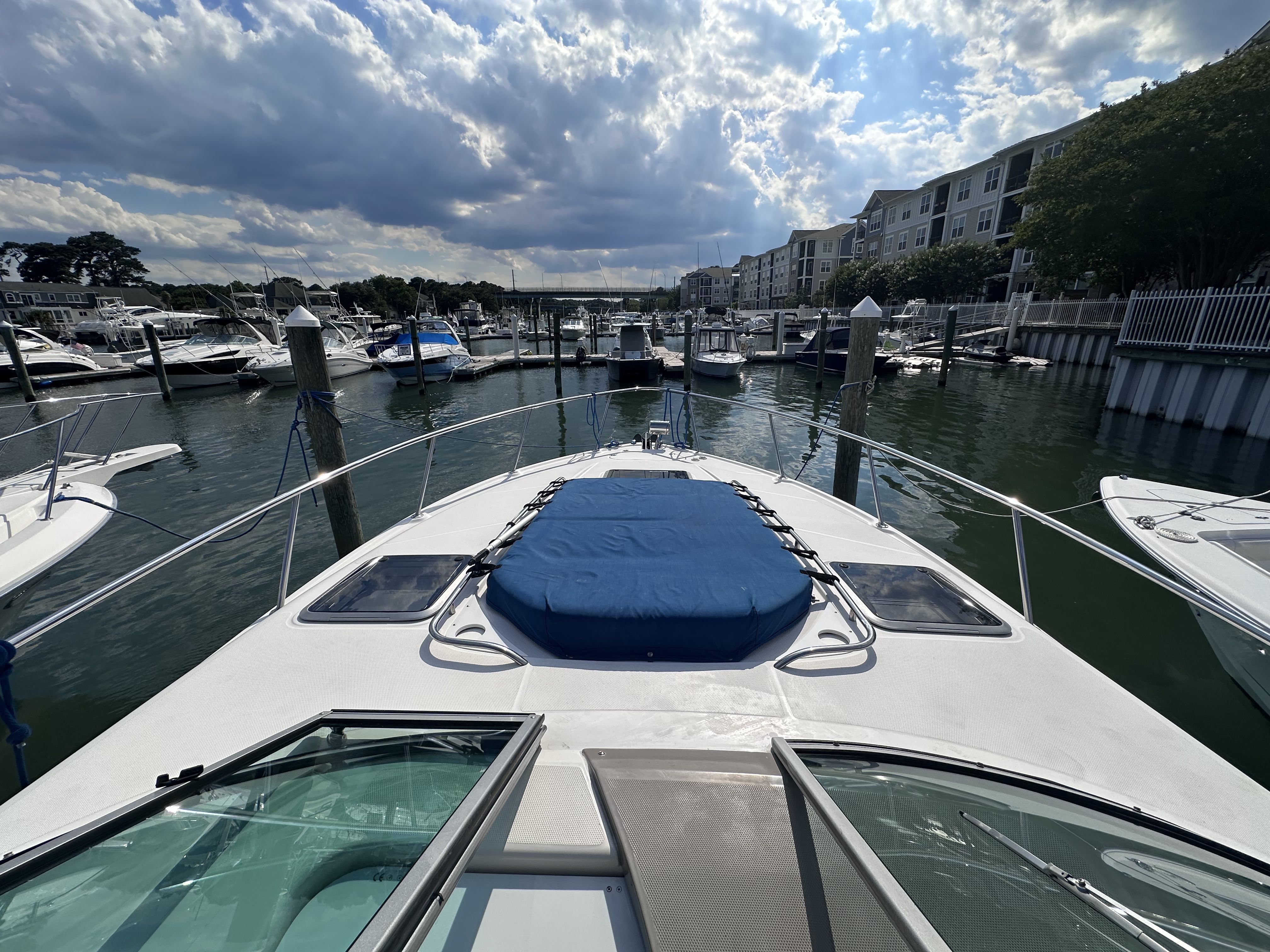 A 2008 Chaparral Signature 330 docked in a busy marina, surrounded by other boats.