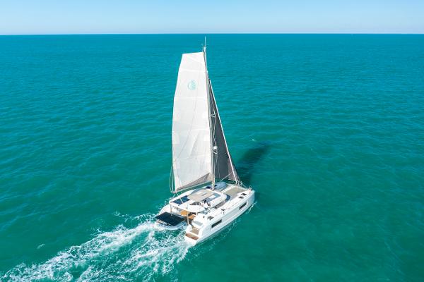 2025 Lagoon 38 catamaran sailing on open turquoise sea.