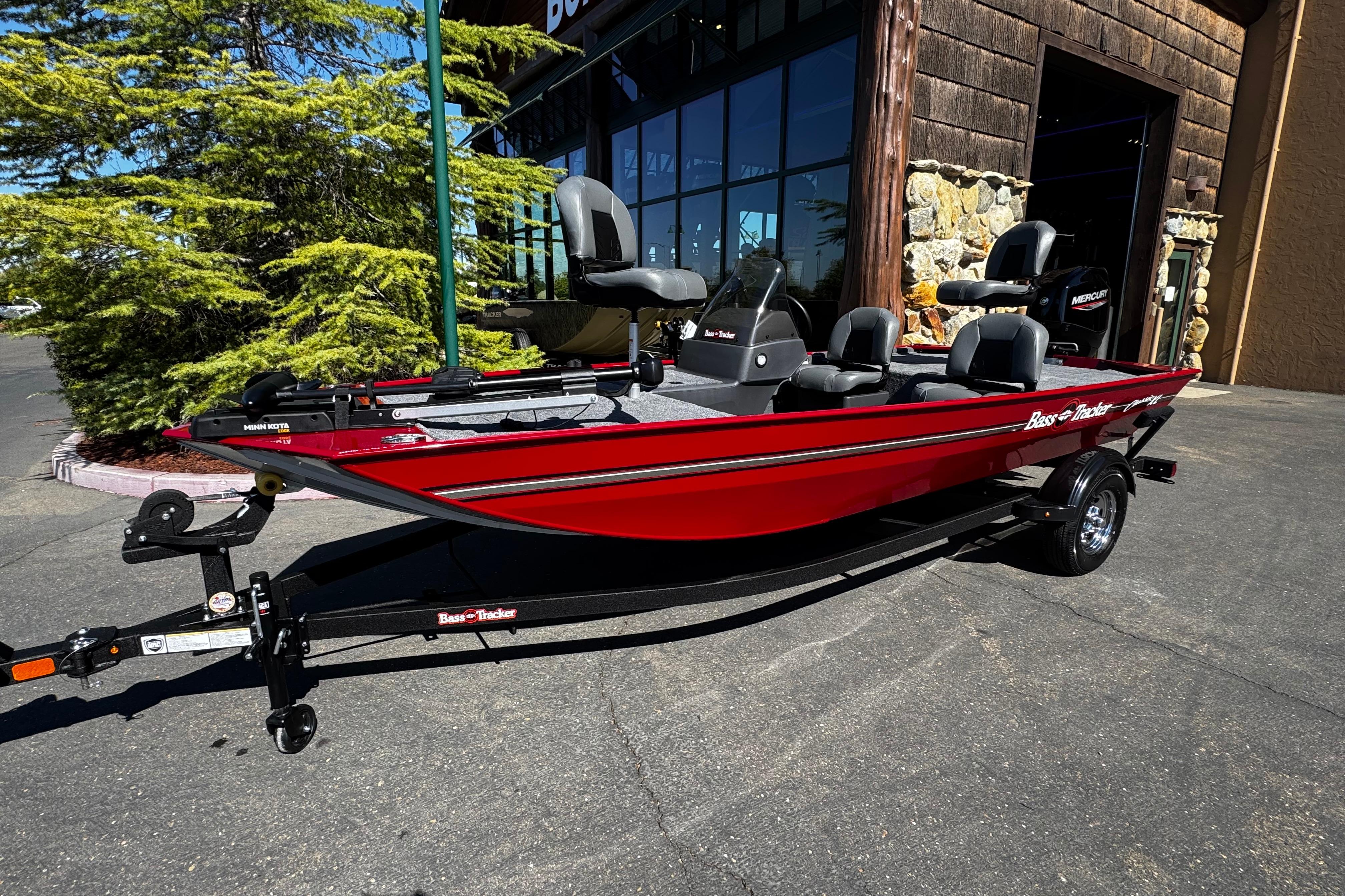 2026 Tracker Bass Tracker Classic XL boat in vibrant red, parked outdoors.