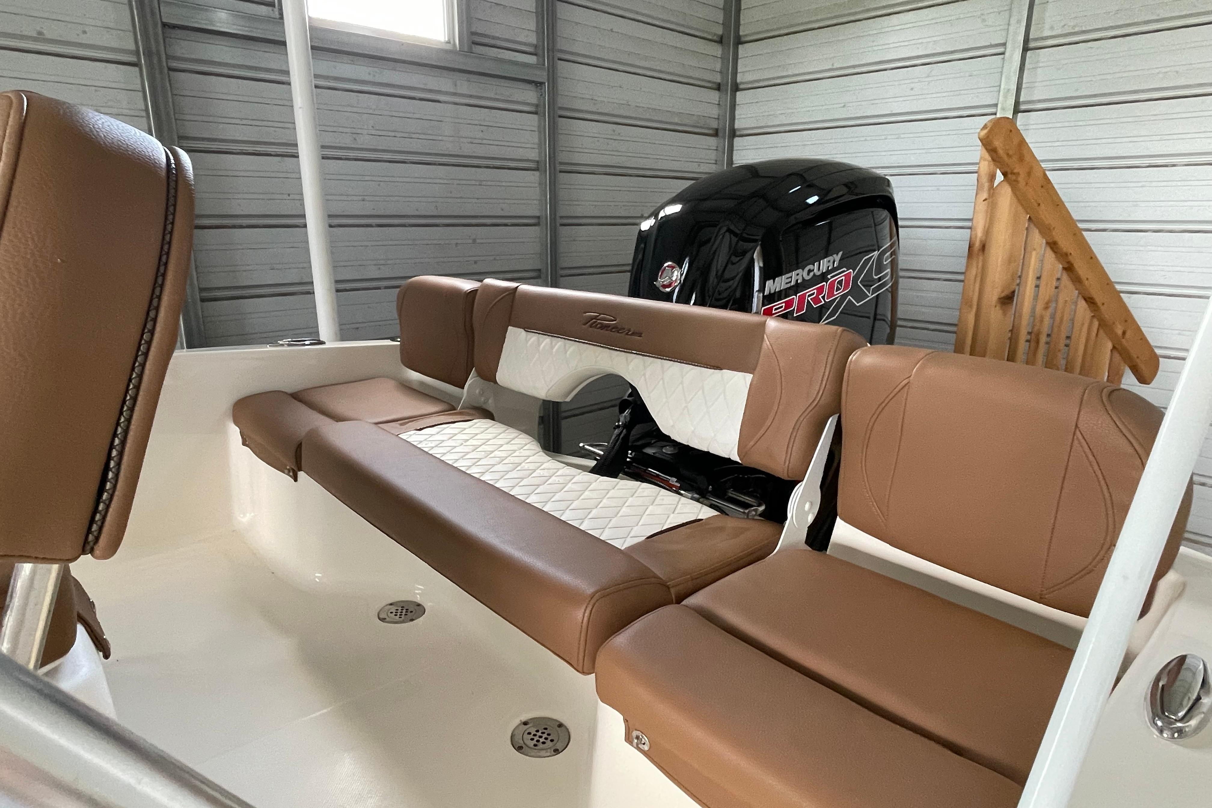 2024 Pioneer 180 Islander boat interior with brown seating and Mercury Pro XS engine.
