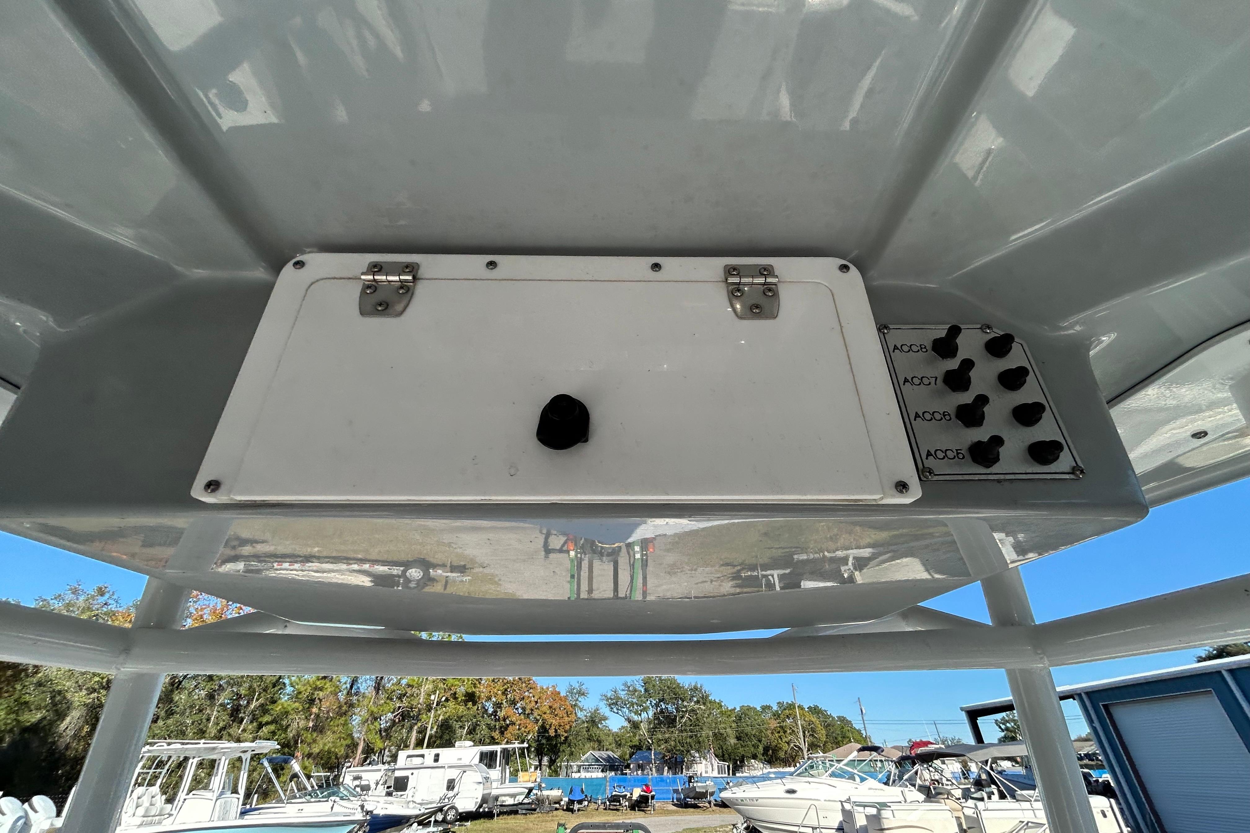 Control panel on a 2022 Clearwater 2300 boat, featuring switches and storage compartment.