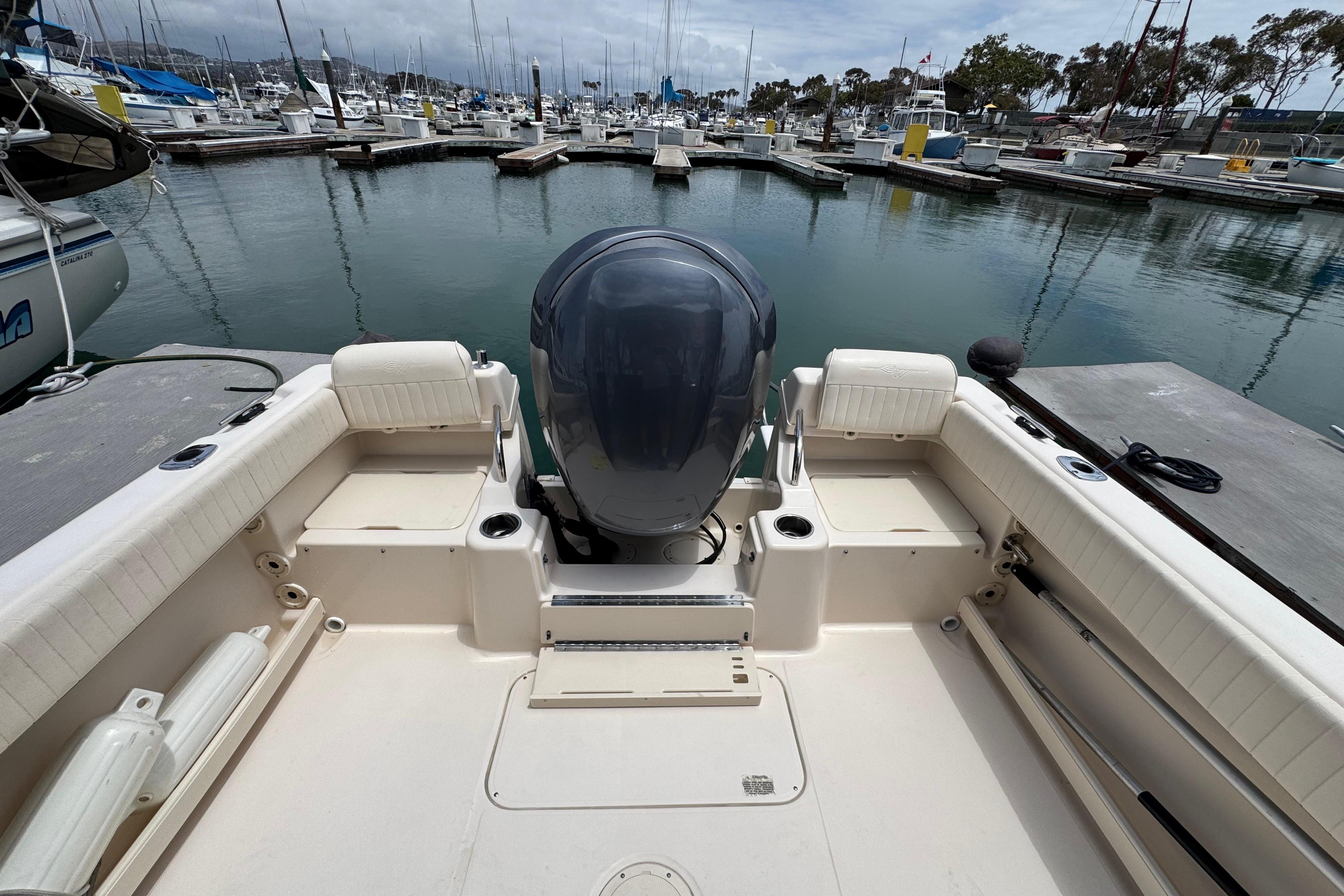2012 Grady-White Adventure 208 boat docked at a marina, showcasing spacious seating and motor.